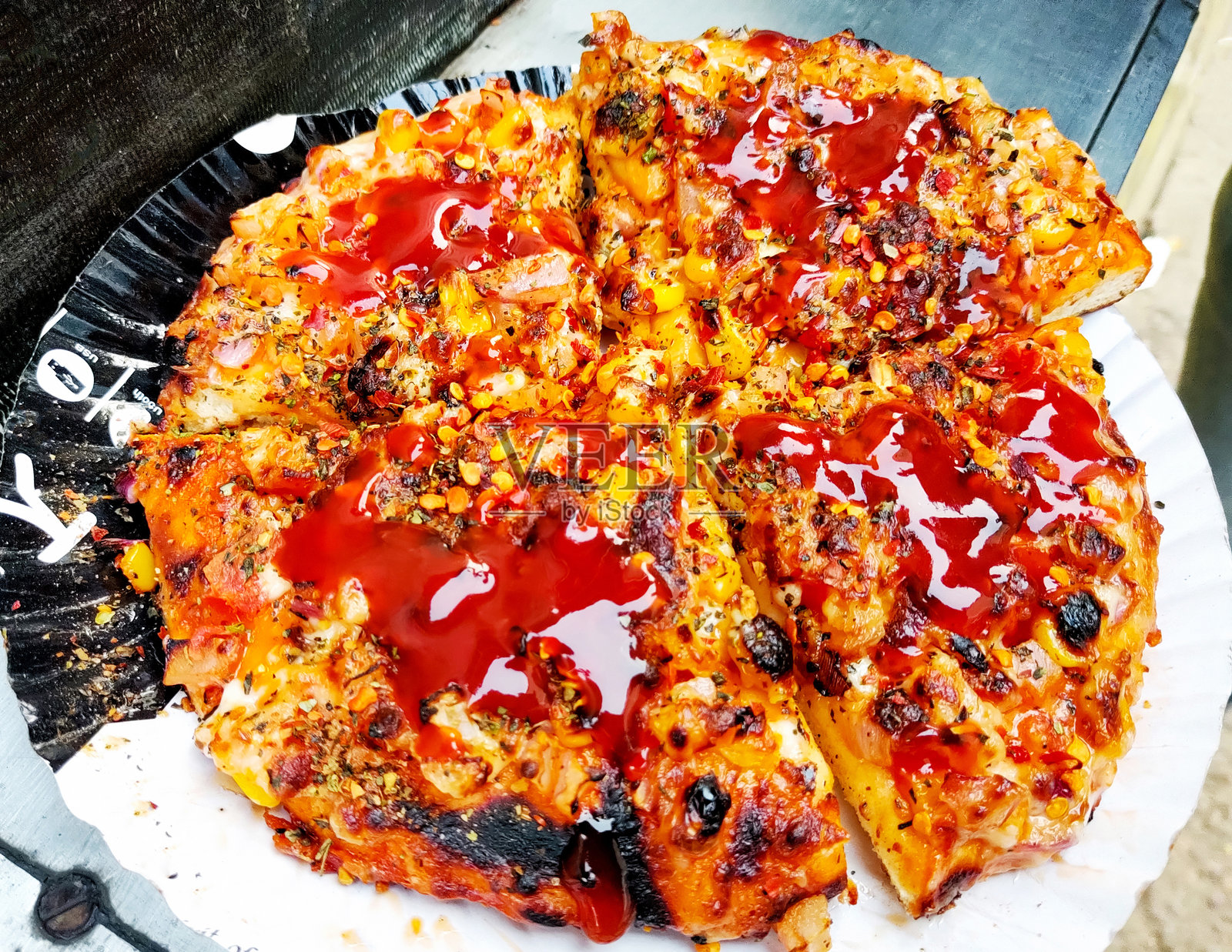 街头风格的披萨,配有芝士、玉米和酱料照片摄影图片