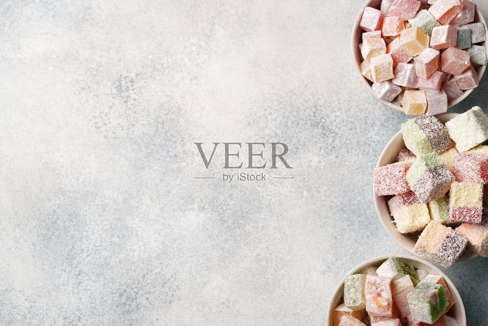 碗中盛放着美味的土耳其软糖,摆放在浅色背景上照片摄影图片