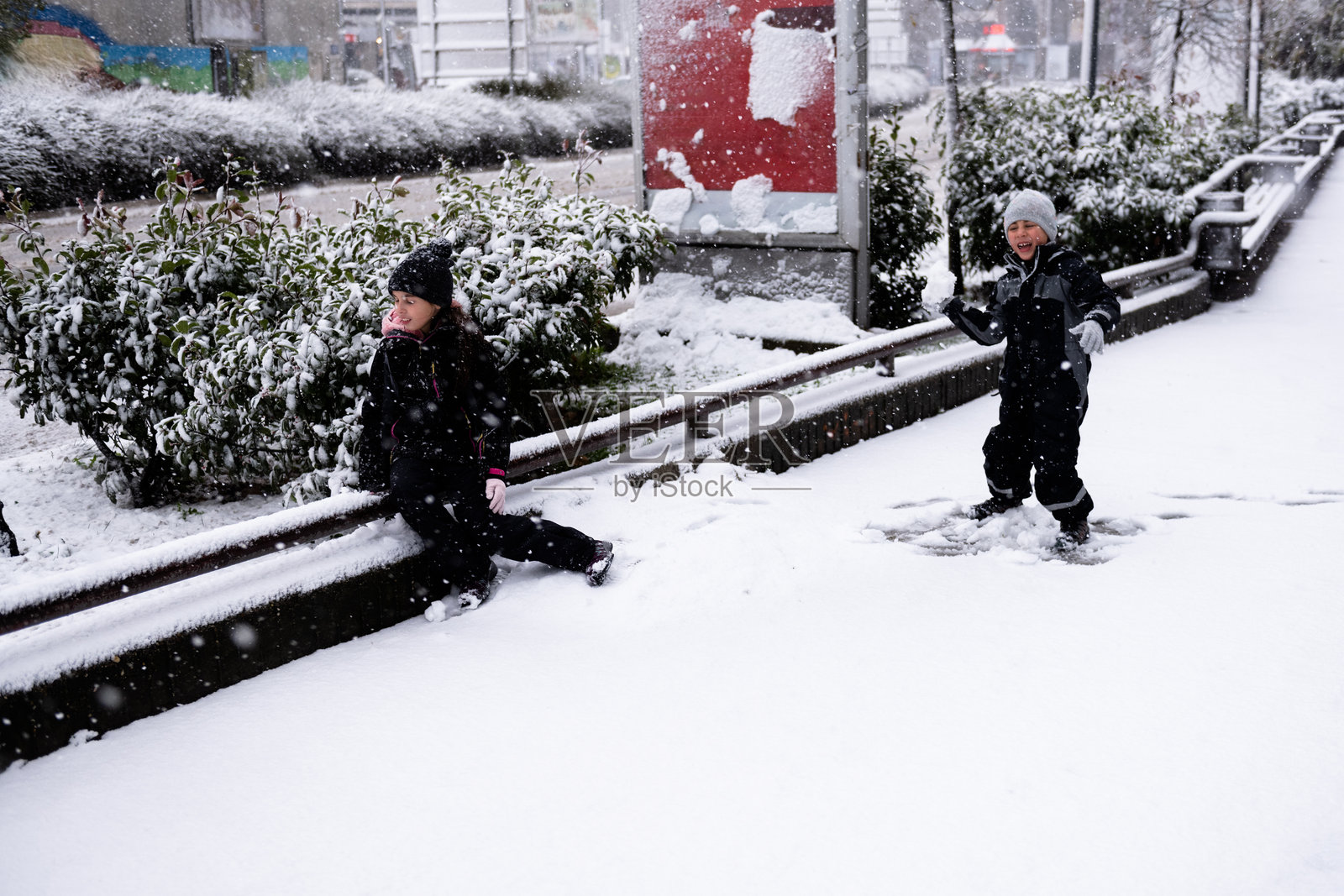 孩子们在冬日飘雪中玩耍在新鲜的雪地上照片摄影图片