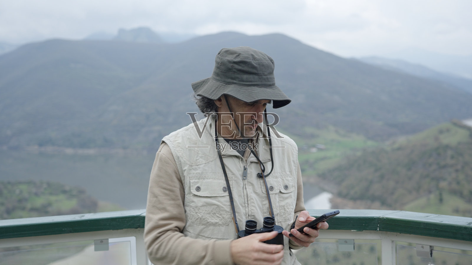 男人在观景台观鸟,远眺峡湾景色照片摄影图片