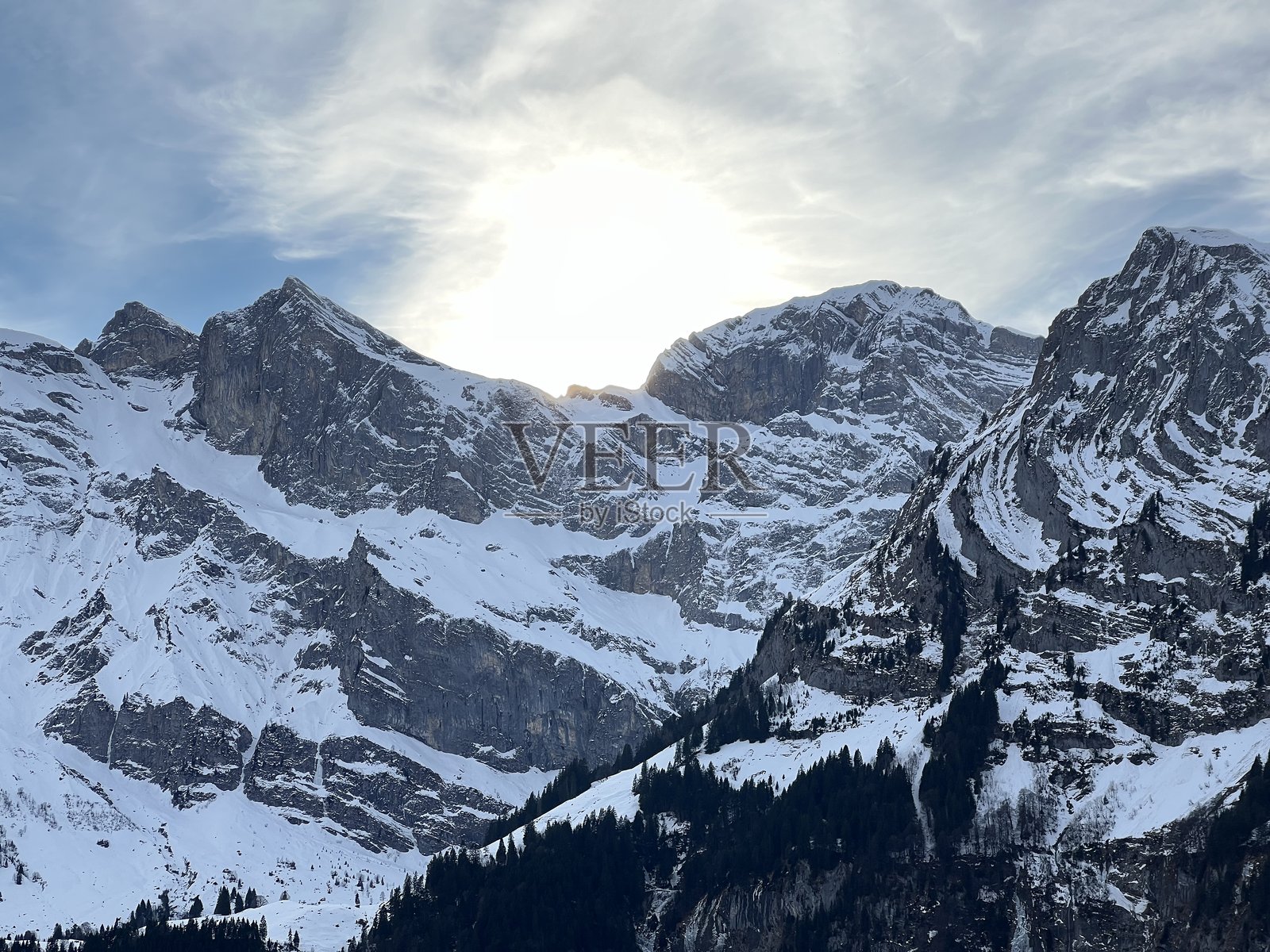 瑞士阿尔卑斯山冬季陡峭的岩石雪山,俯瞰着瑞士的恩格尔贝格(Engelberg)小镇 - 瓦尔登州(Kanton Obwalden, Schweiz)照片摄影图片