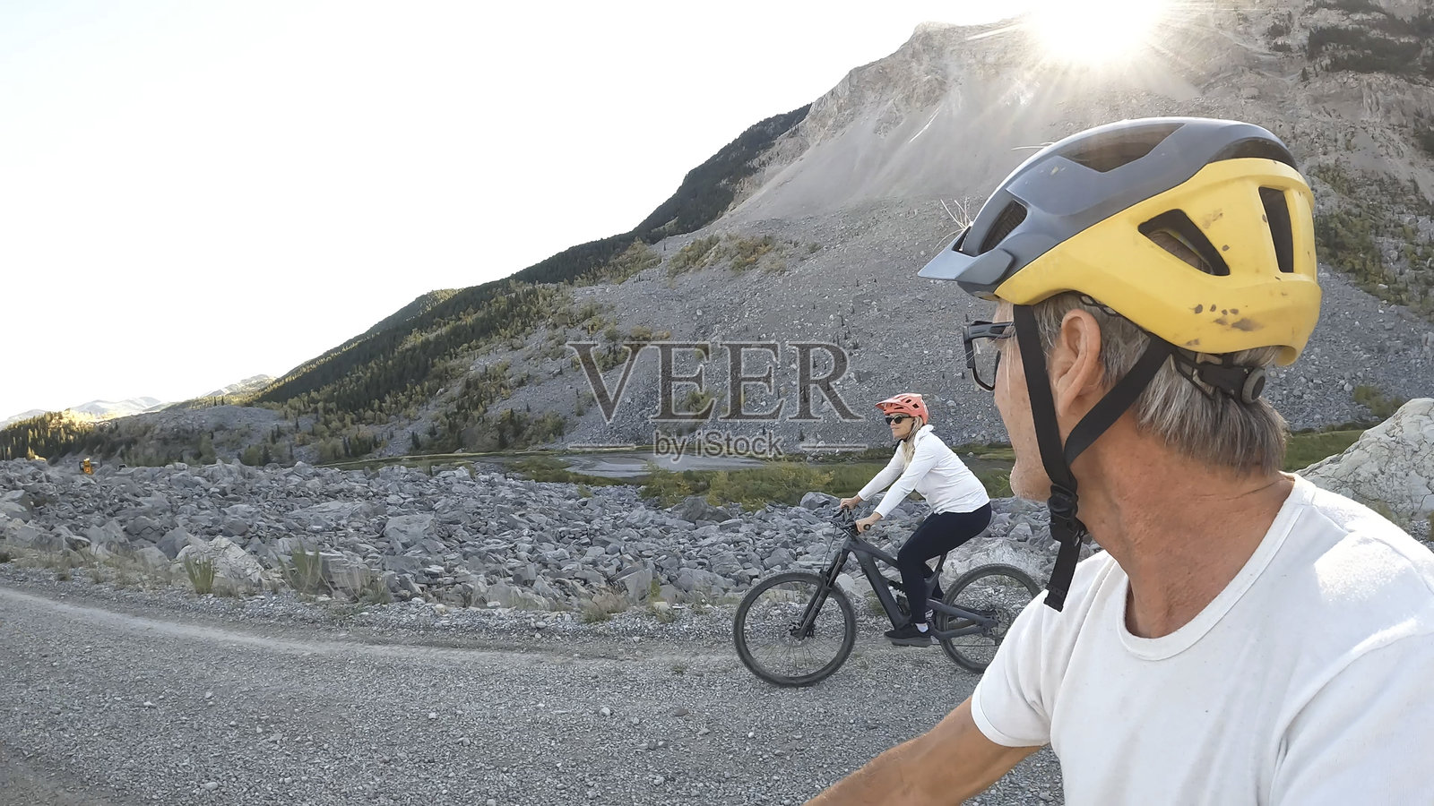 情侣骑行电动自行车在山路上行驶的个人视角照片摄影图片