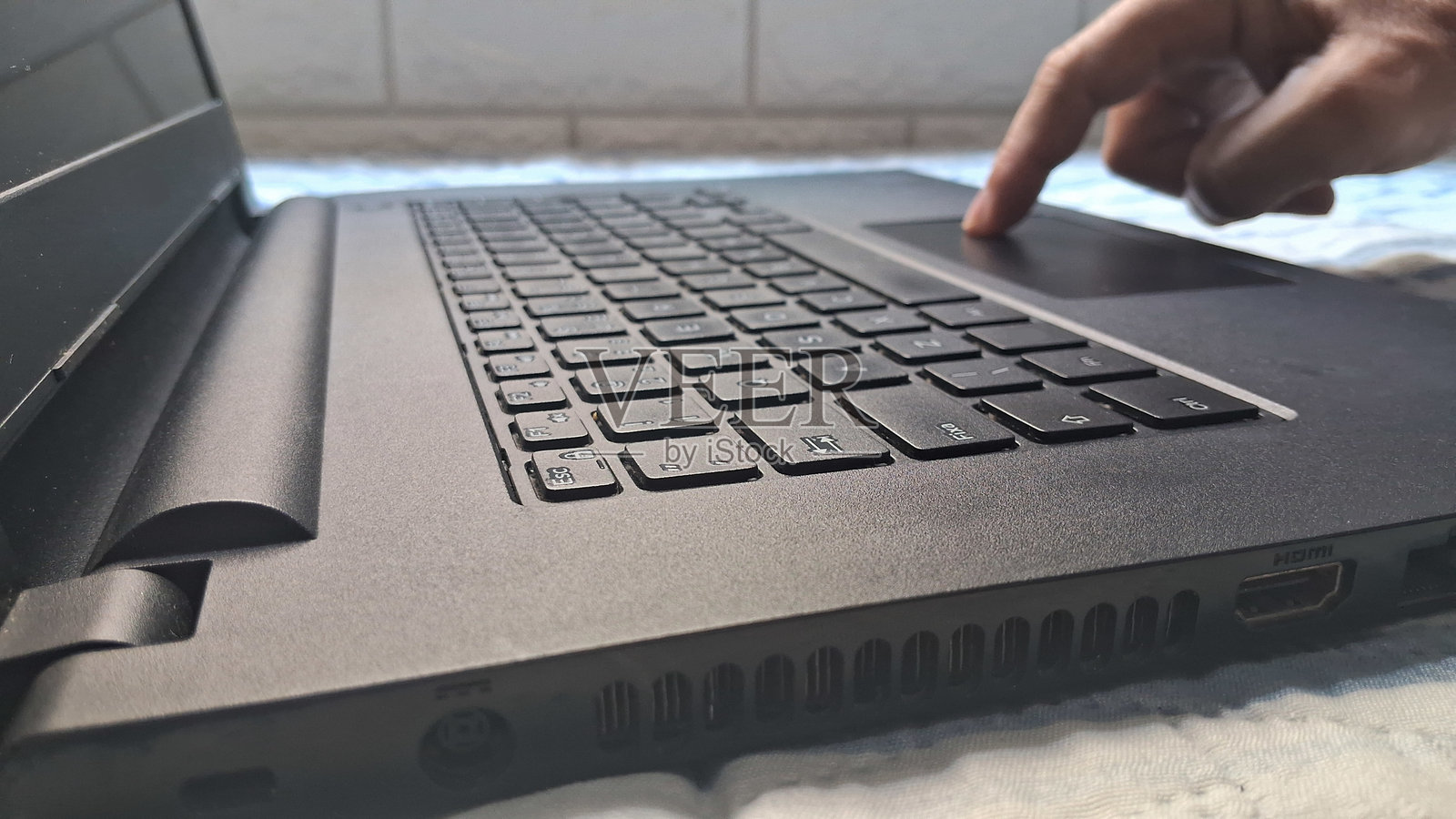 床上用笔记本电脑打字的手照片摄影图片