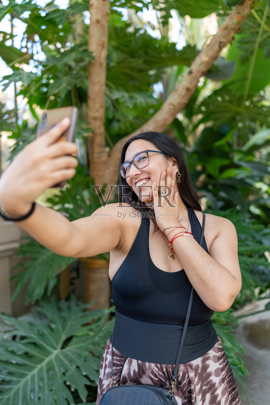 快乐的拉丁裔女性在户外旅行时用手机自拍照片摄影图片