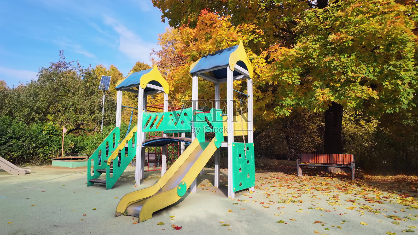 金黄枫树下的秋日游乐场照片摄影图片