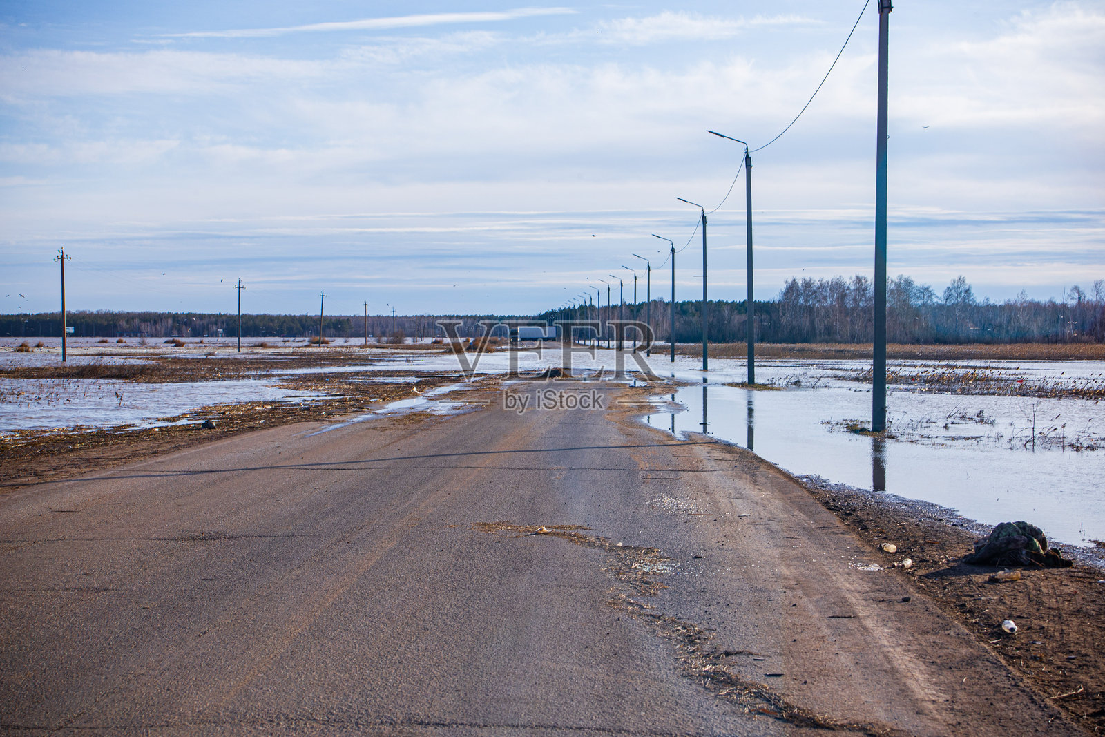 洪水和春季洪水期间被淹没的道路、被封锁的道路和高速公路,道路问题以及加固的大坝和堤防照片摄影图片