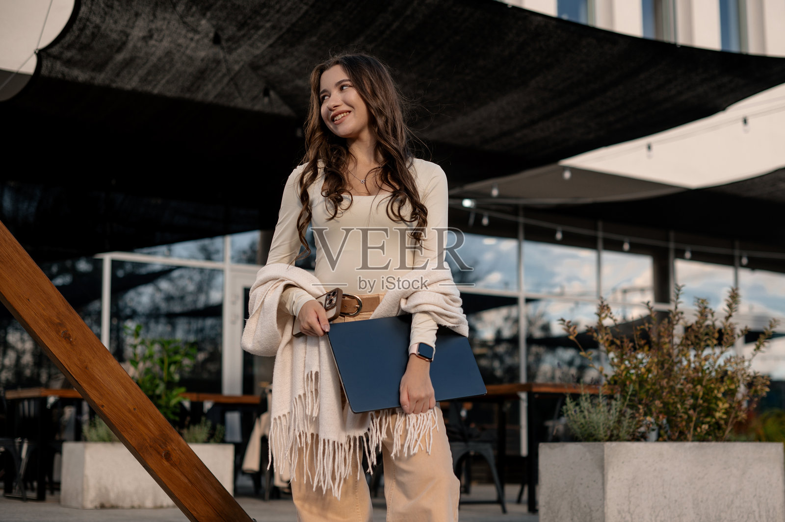 带着笔记本电脑在户外微笑的女士照片摄影图片