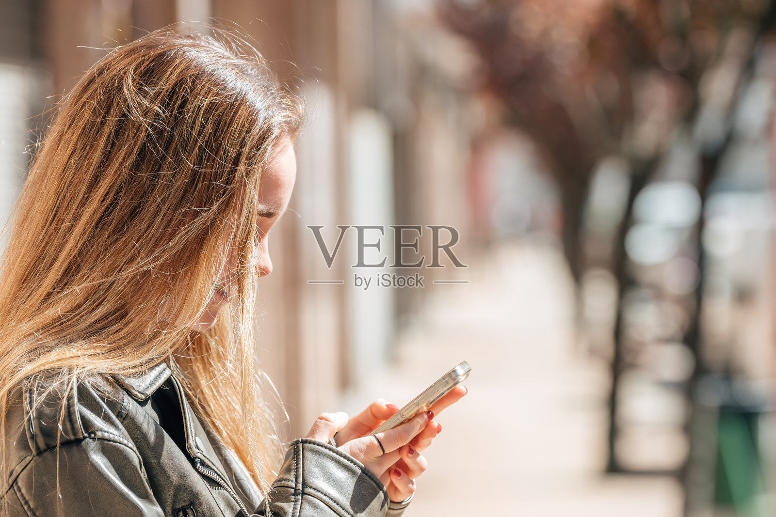 金发女孩在街上使用手机照片摄影图片