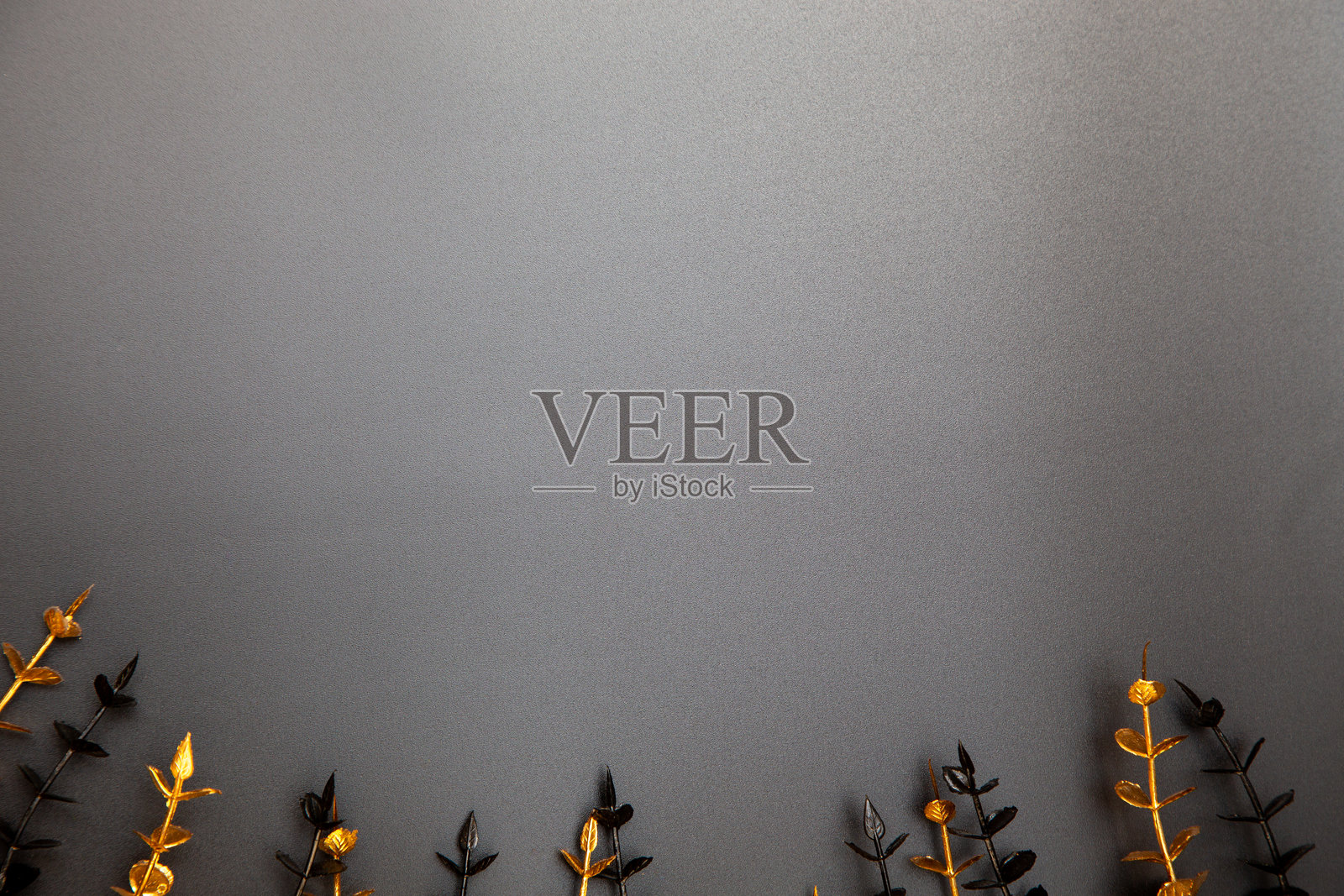 金色和黑色的装饰性树枝在深色背景上构成简约时尚的构图,留有空白文字空间。照片摄影图片