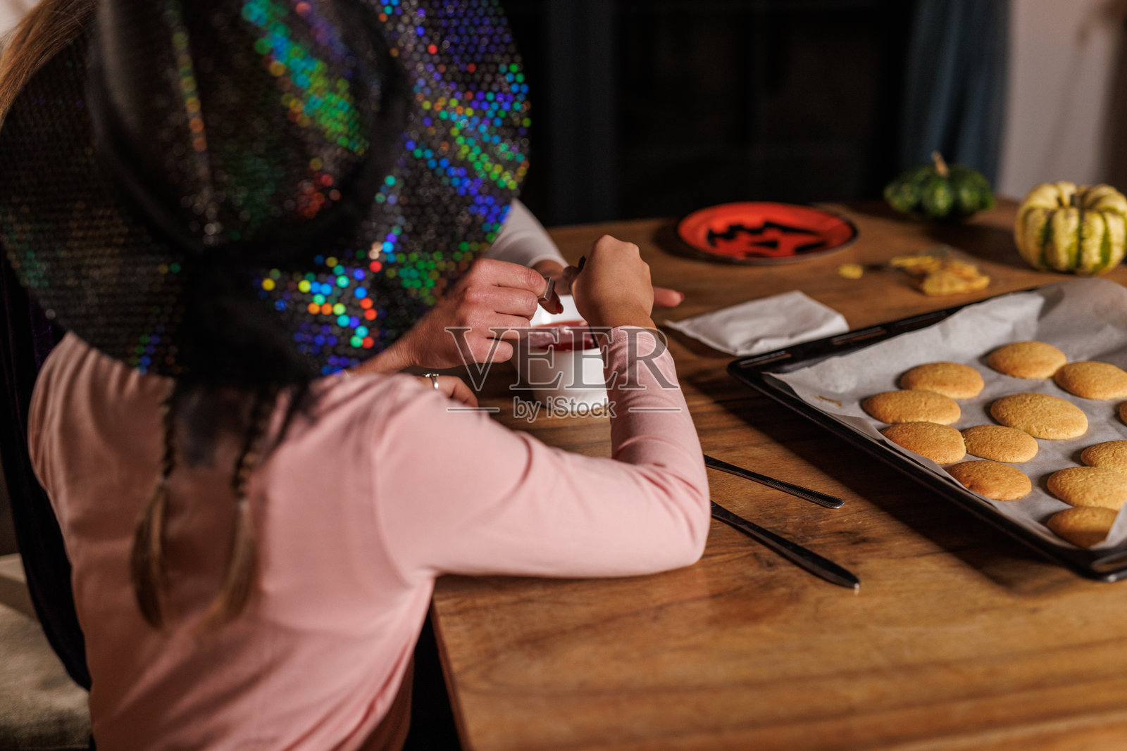 妈妈和女儿正在为万圣节装饰饼干照片摄影图片