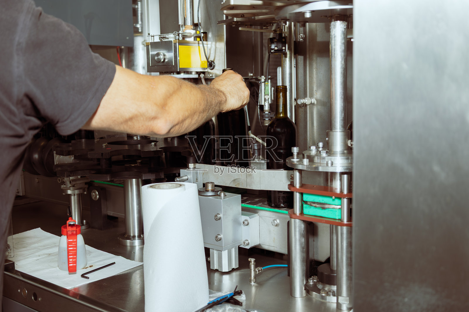 工人正在工厂的生产线上装瓶葡萄酒照片摄影图片