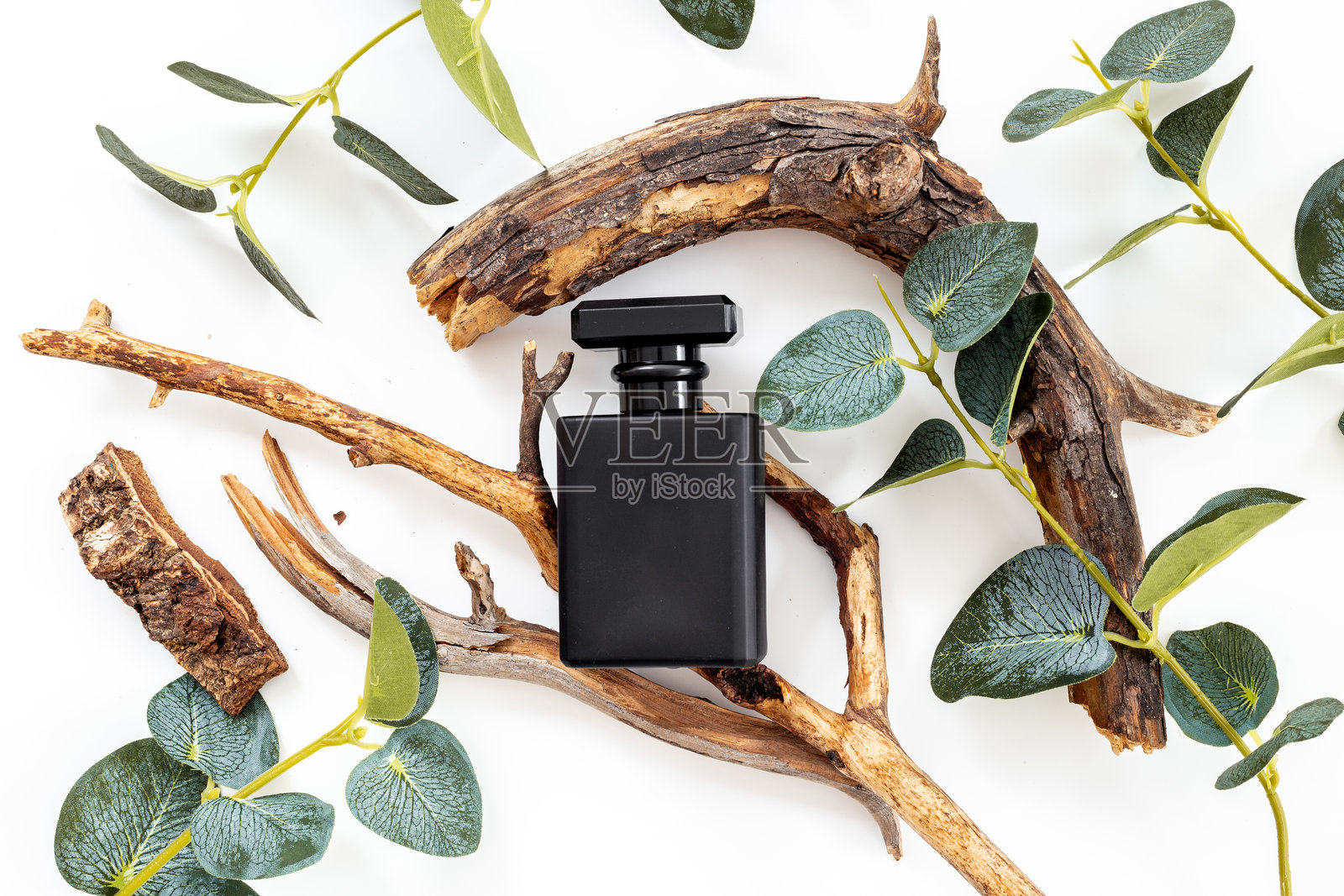 时尚的黑色香水瓶搭配沉香木。男性香水概念。照片摄影图片