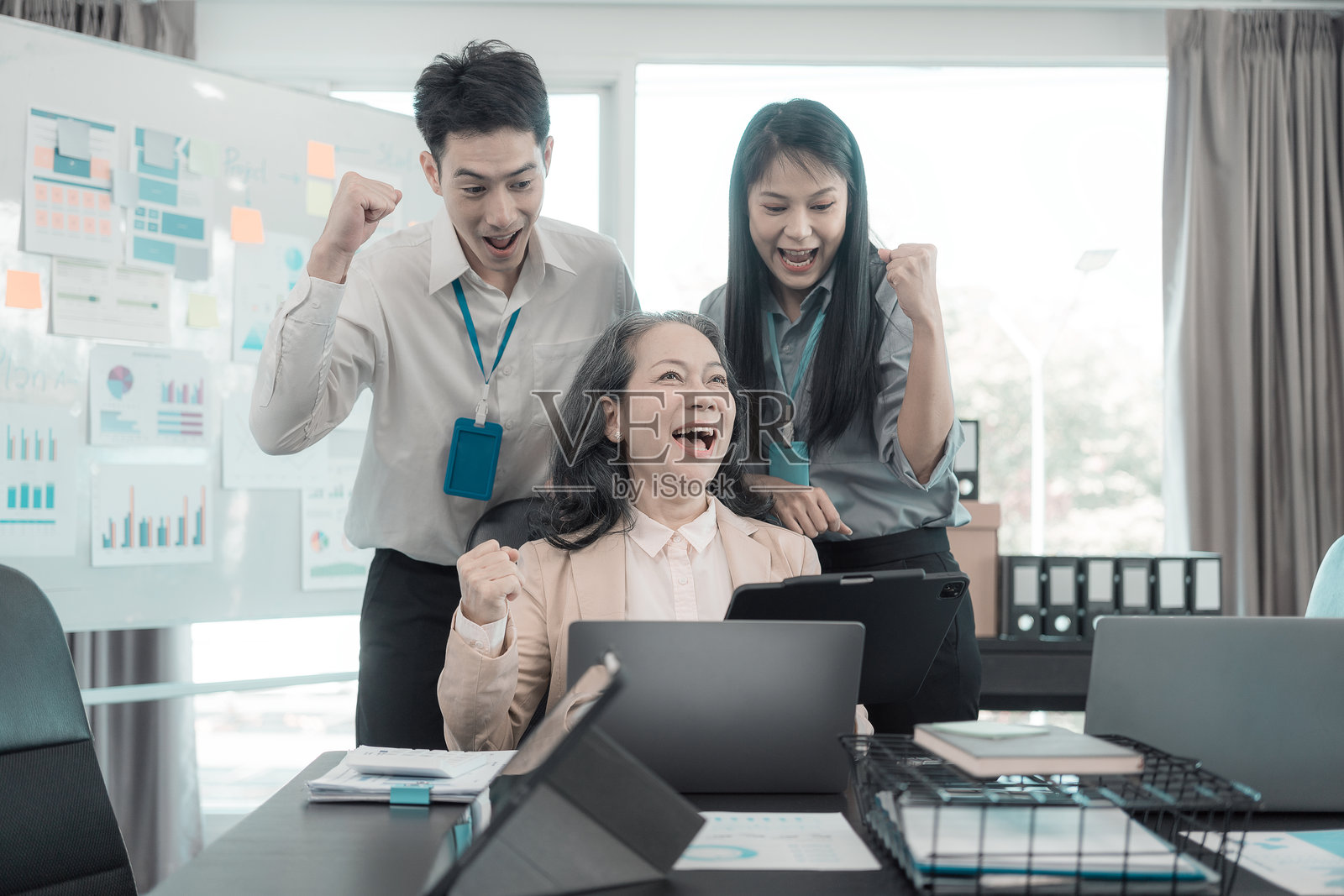 一群成功的亚洲商界人士在公司办公室会议室里,面带笑容,开怀大笑,一起摆姿势并做出快乐的手势。照片摄影图片