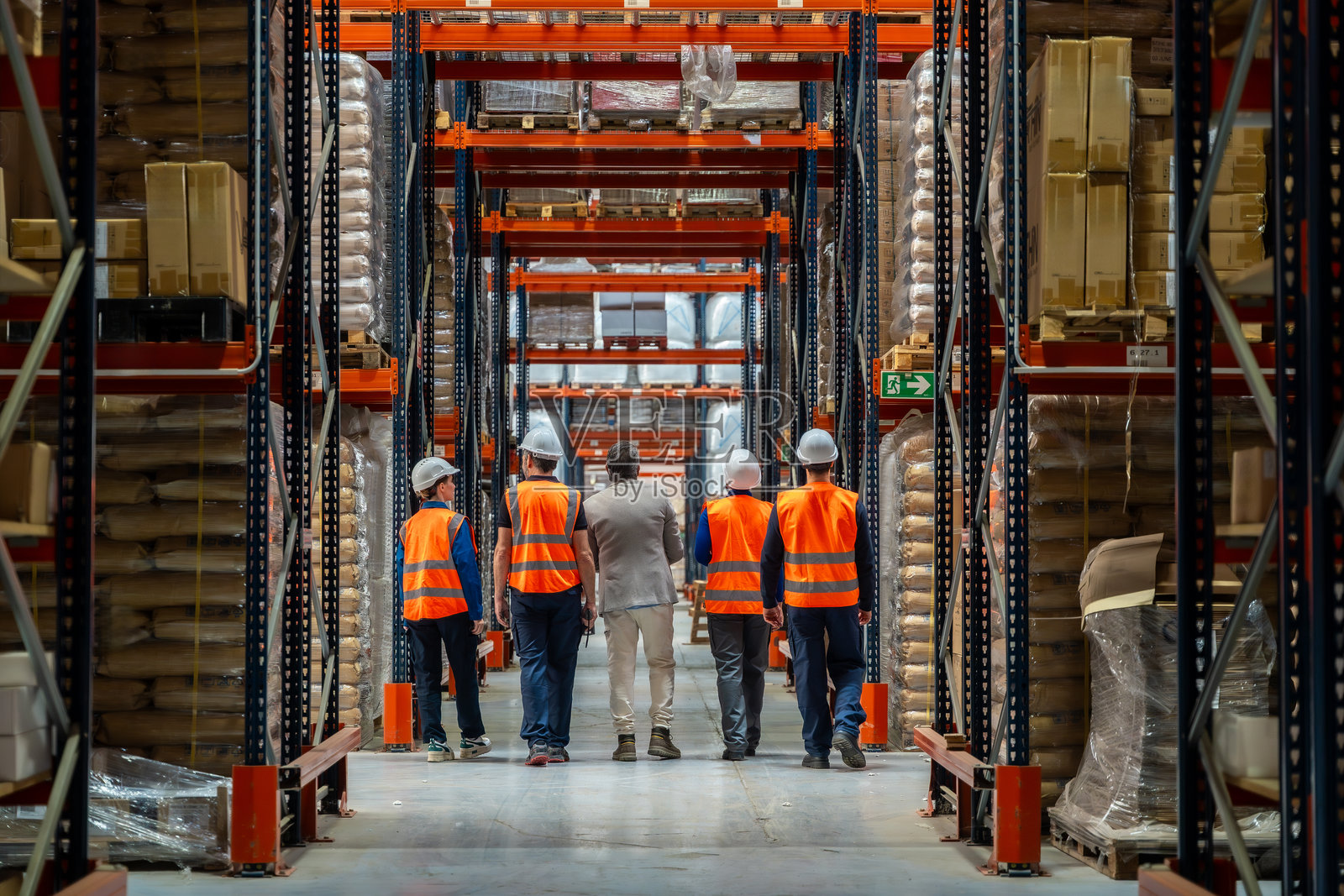 物流团队在宽敞的配送仓库过道中行走照片摄影图片