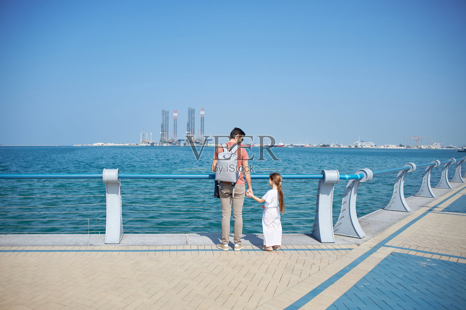 父亲牵着女儿的手,享受着散步的风景照片摄影图片