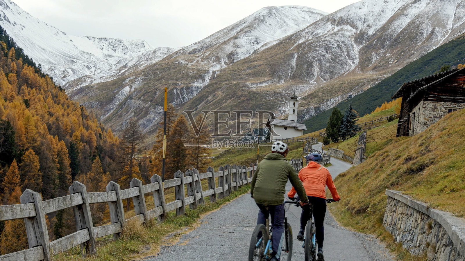 一对成熟的夫妇沿着乡村公路在山中骑行电动自行车照片摄影图片