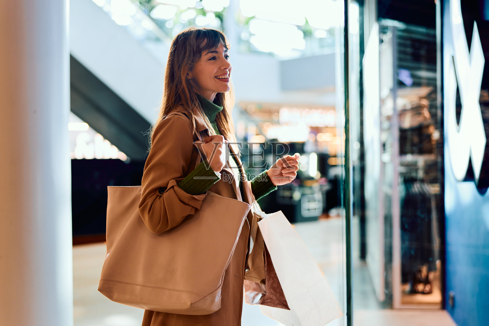 快乐的女士在逛街浏览橱窗照片摄影图片