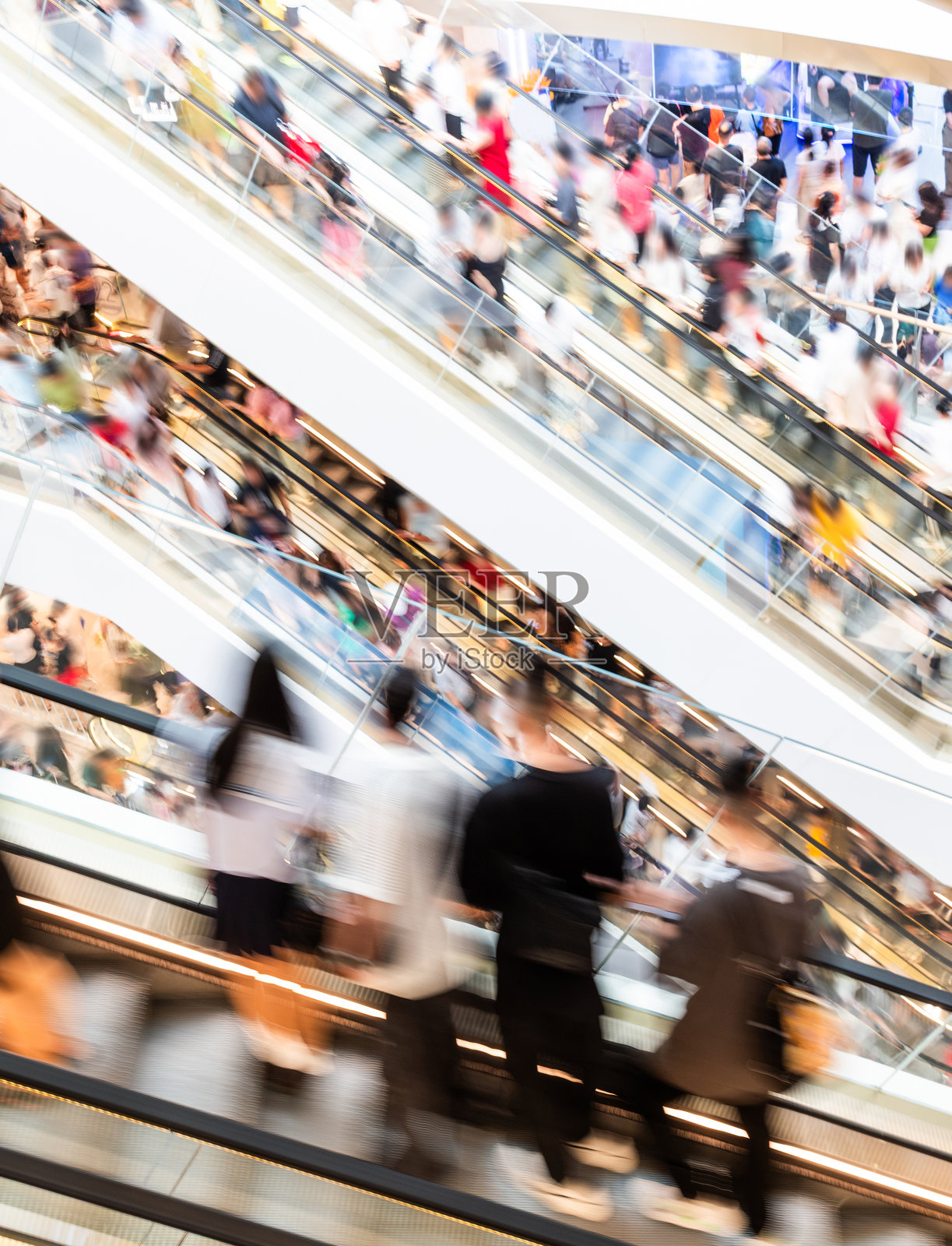 现代购物中心扶梯上模糊移动的拥挤人群照片摄影图片