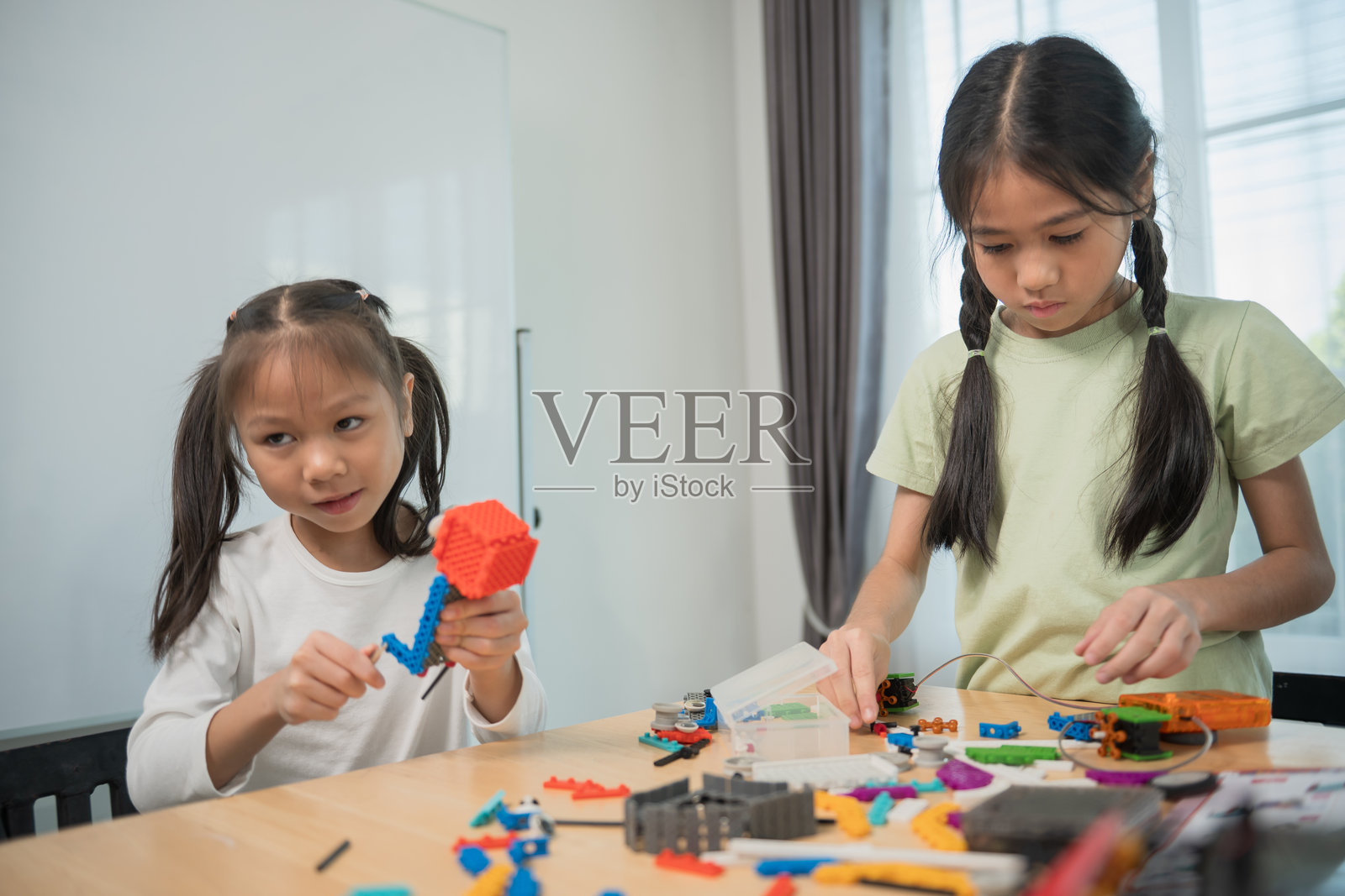 孩子们在桌子上玩积木,小朋友们用彩色塑料积木玩耍和搭建。照片摄影图片