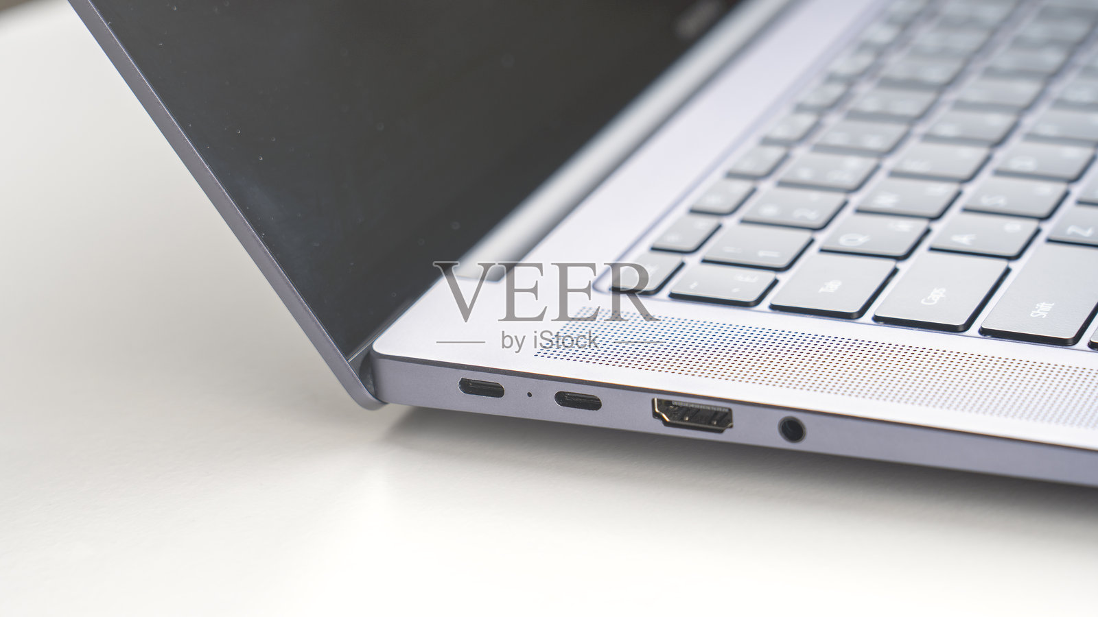 一台笔记本电脑打开着,显示键盘和已关闭的屏幕照片摄影图片