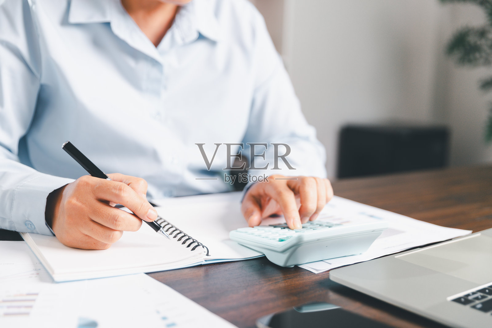 女商人通过使用银行和会计系统来计算成本、税收和投资来管理财务,说明了专注于财务战略的商业、金融和房地产概念。照片摄影图片