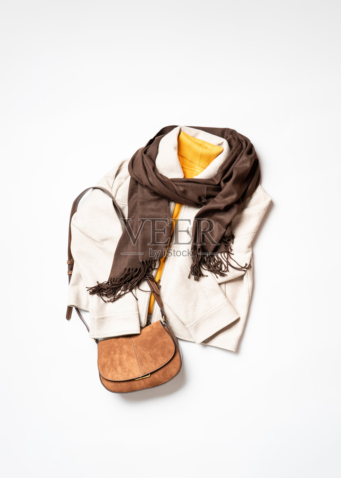 白色背景上的秋季服装和配饰。围巾、黄色毛衣和包包。俯视拍摄,留有复制空间。照片摄影图片