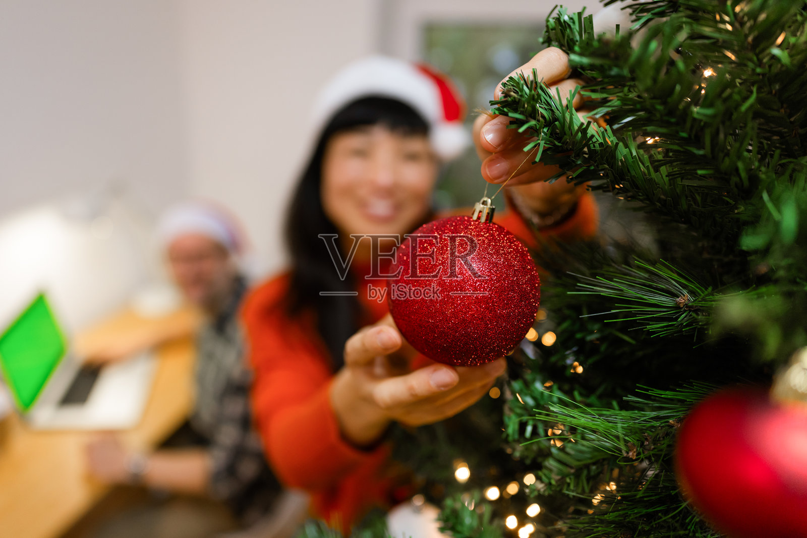 日本女性在圣诞树上装饰饰品照片摄影图片