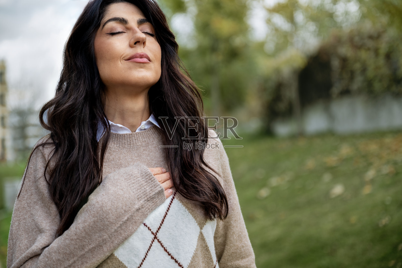 一位放松的女士在秋天的城市里呼吸新鲜空气照片摄影图片