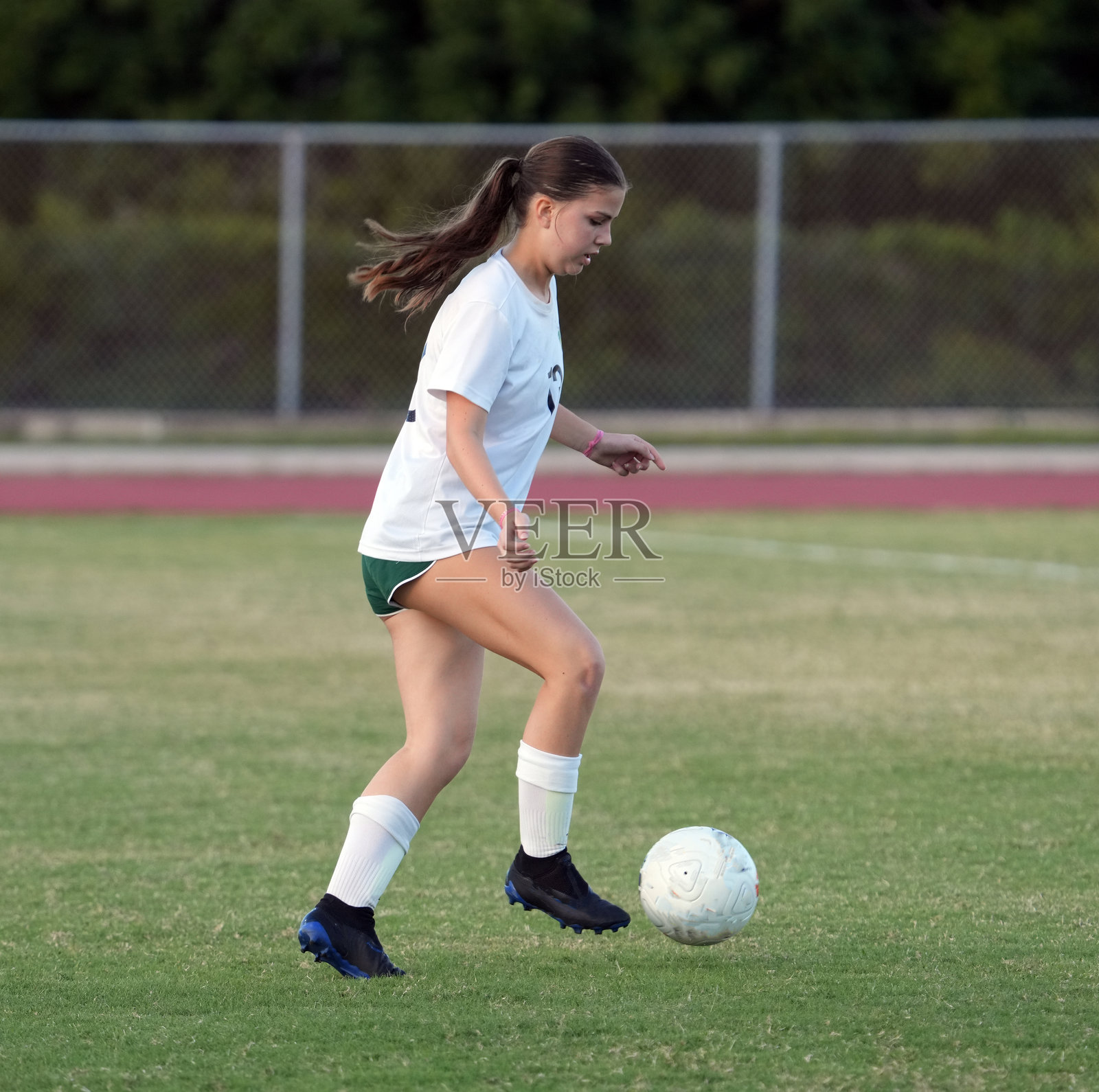 青年足球运动员在足球场上照片摄影图片