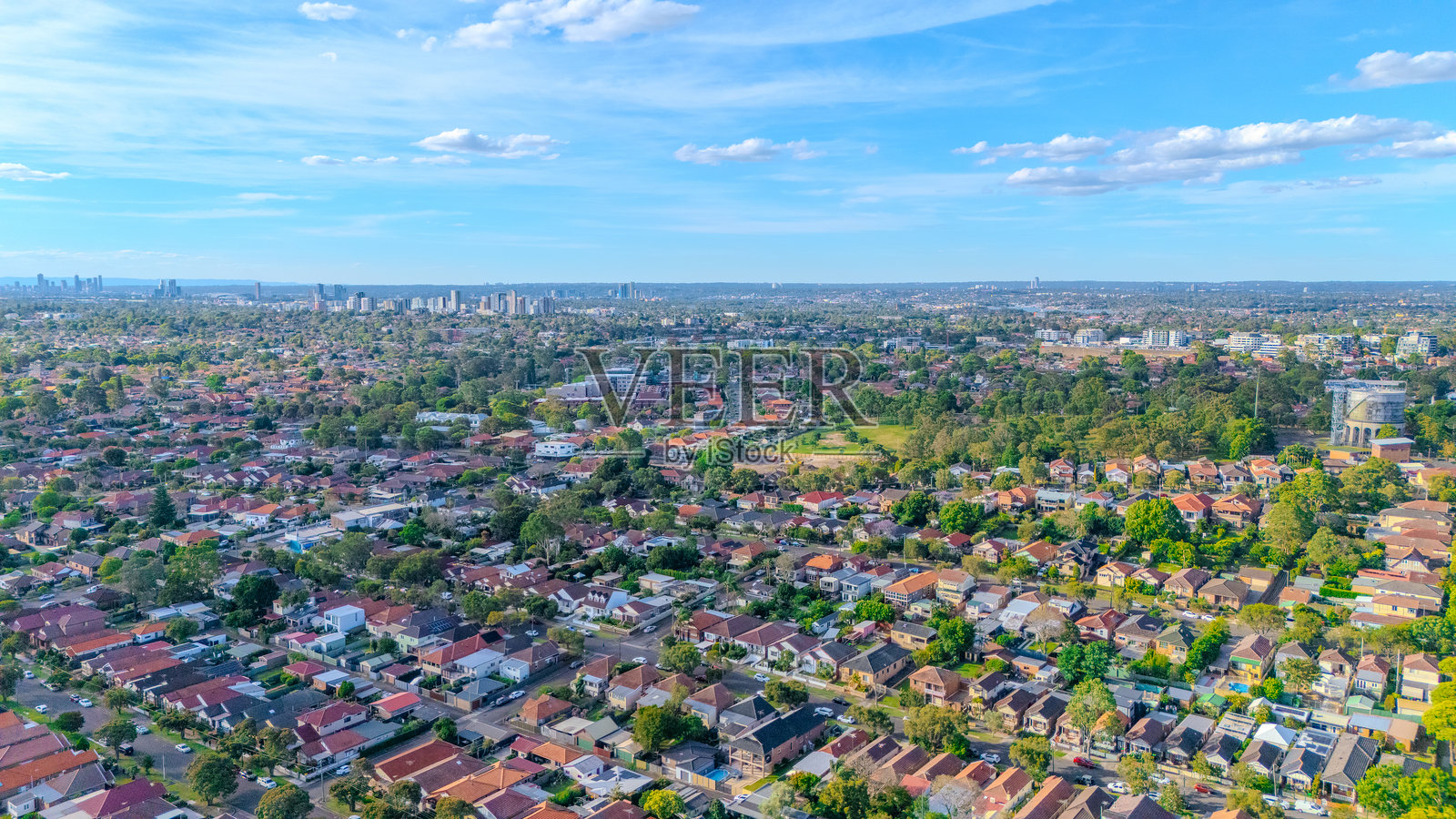 澳大利亚新南威尔士州悉尼西部内陆郊区阿什伯里的航拍全景无人机视角,展现了城市蔓延以及郊区屋顶、街道和树木的陶土色调。照片摄影图片