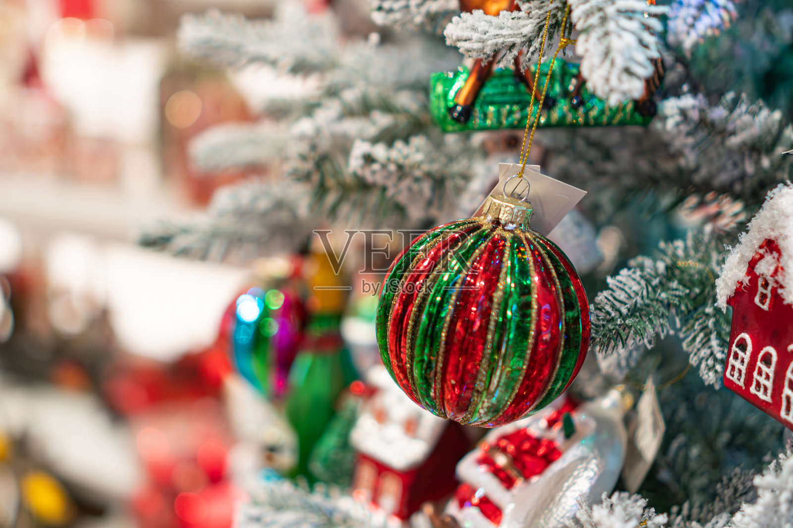 装饰着以红绿色为主的彩色饰品、雪花饰品、中心装饰的人工圣诞树,柔和的灯光,温馨的氛围,室内环境,模糊的背景。照片摄影图片