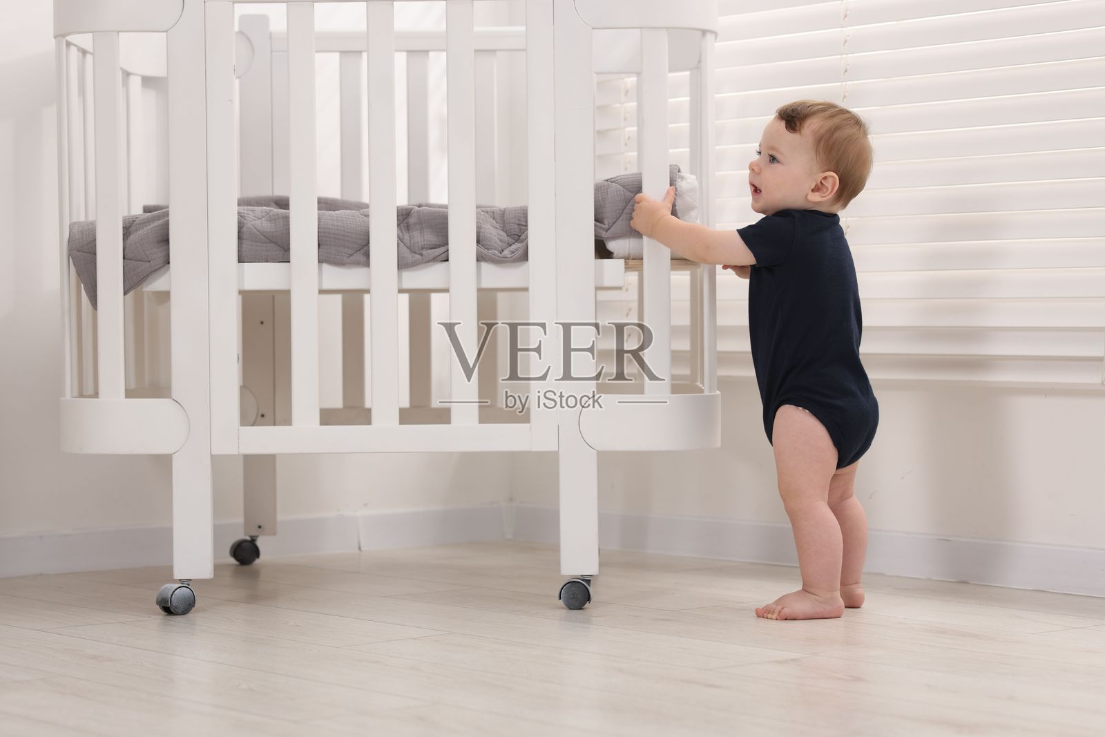 可爱的小宝宝在家婴儿床边照片摄影图片