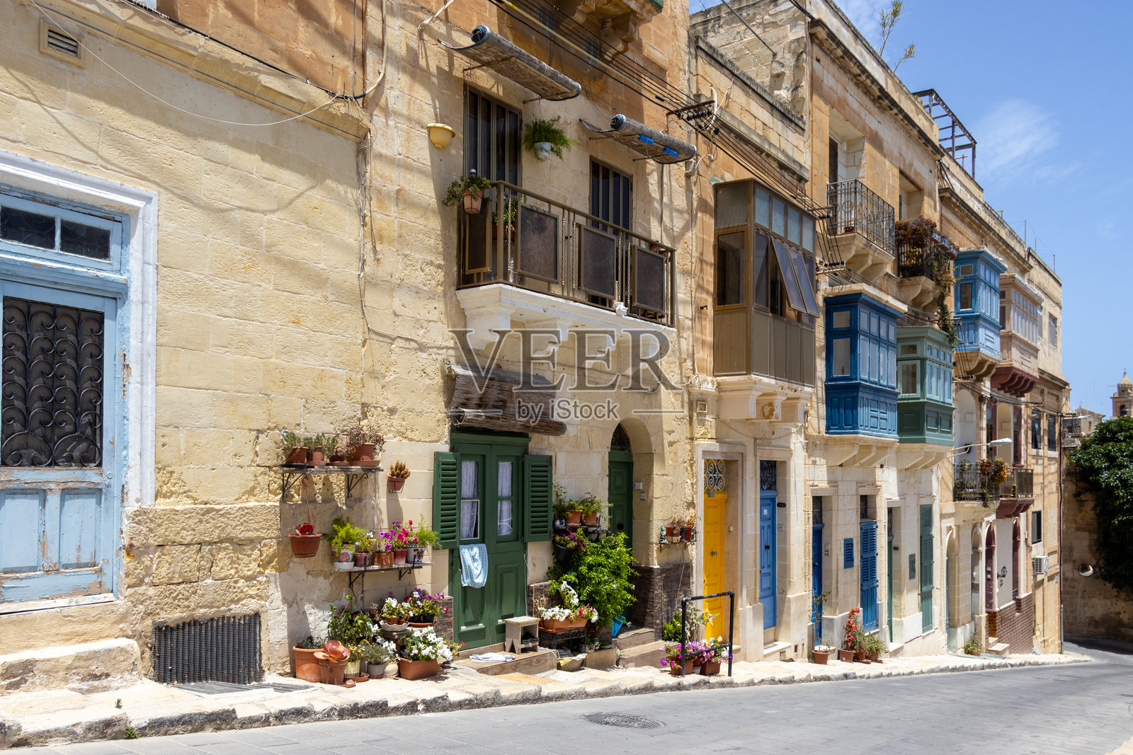 马耳他比尔古的街道,房屋外观,色彩各异的门,典型的阳台,窗户百叶窗和盛开的鲜花照片摄影图片
