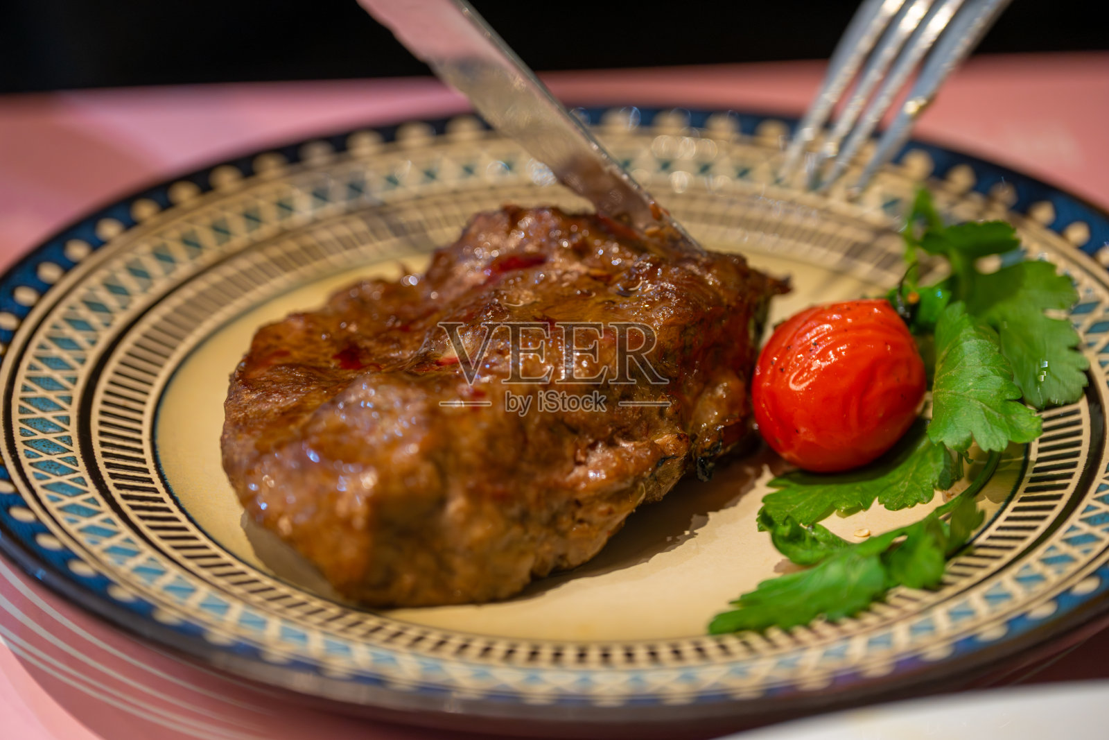 装饰盘上烤牛排配樱桃番茄和香菜照片摄影图片