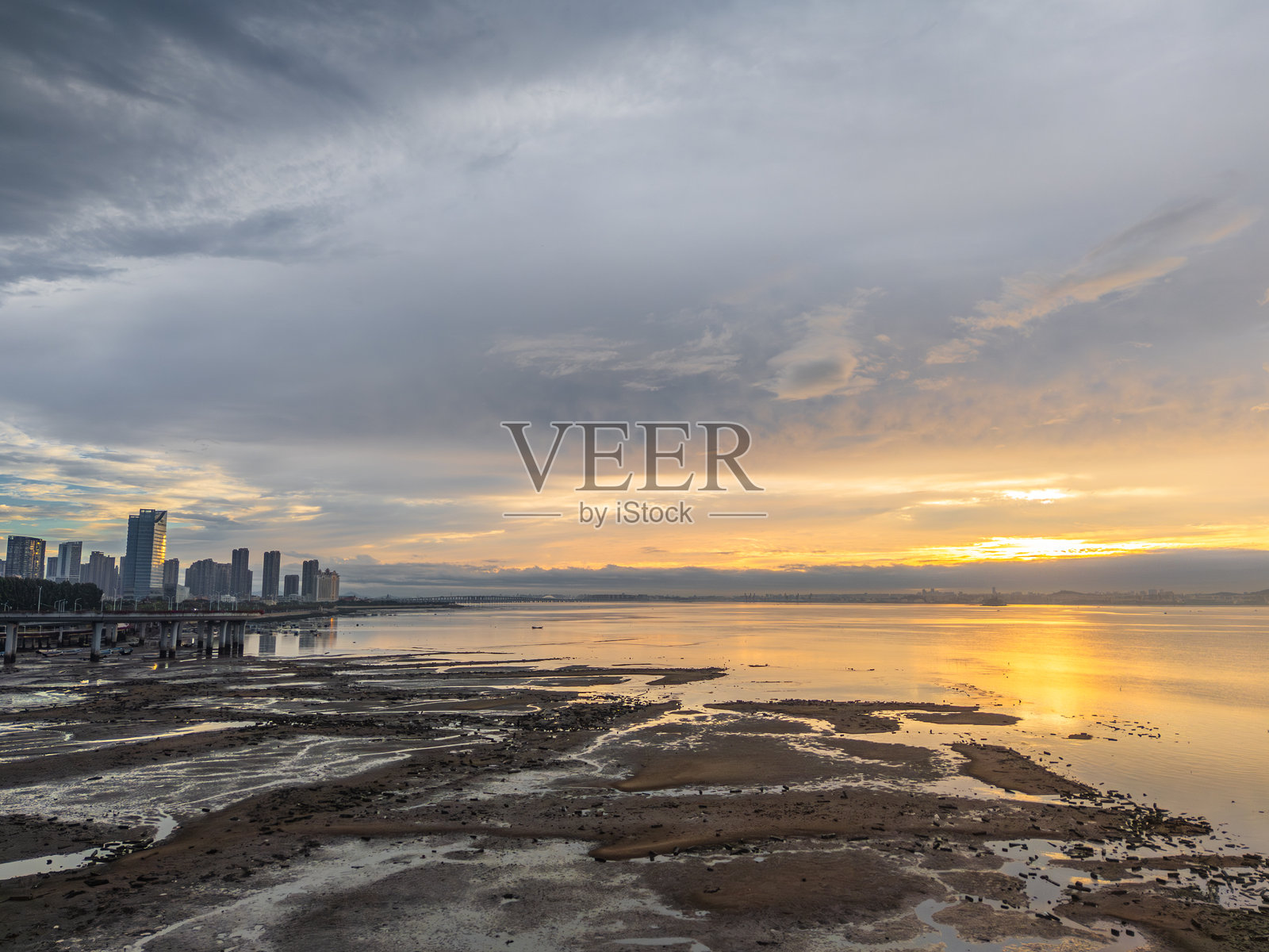 城市天际线与日落湖景,戏剧性的云彩和倒影照片摄影图片
