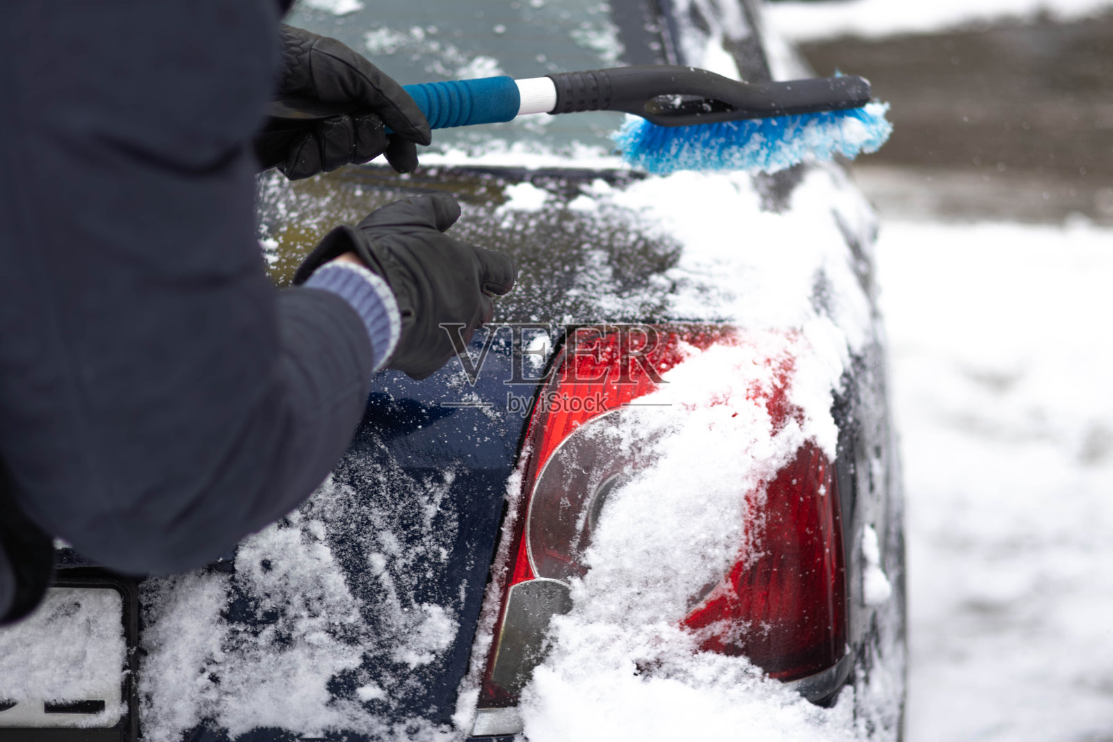 冬季在居民区为汽车清理积雪照片摄影图片