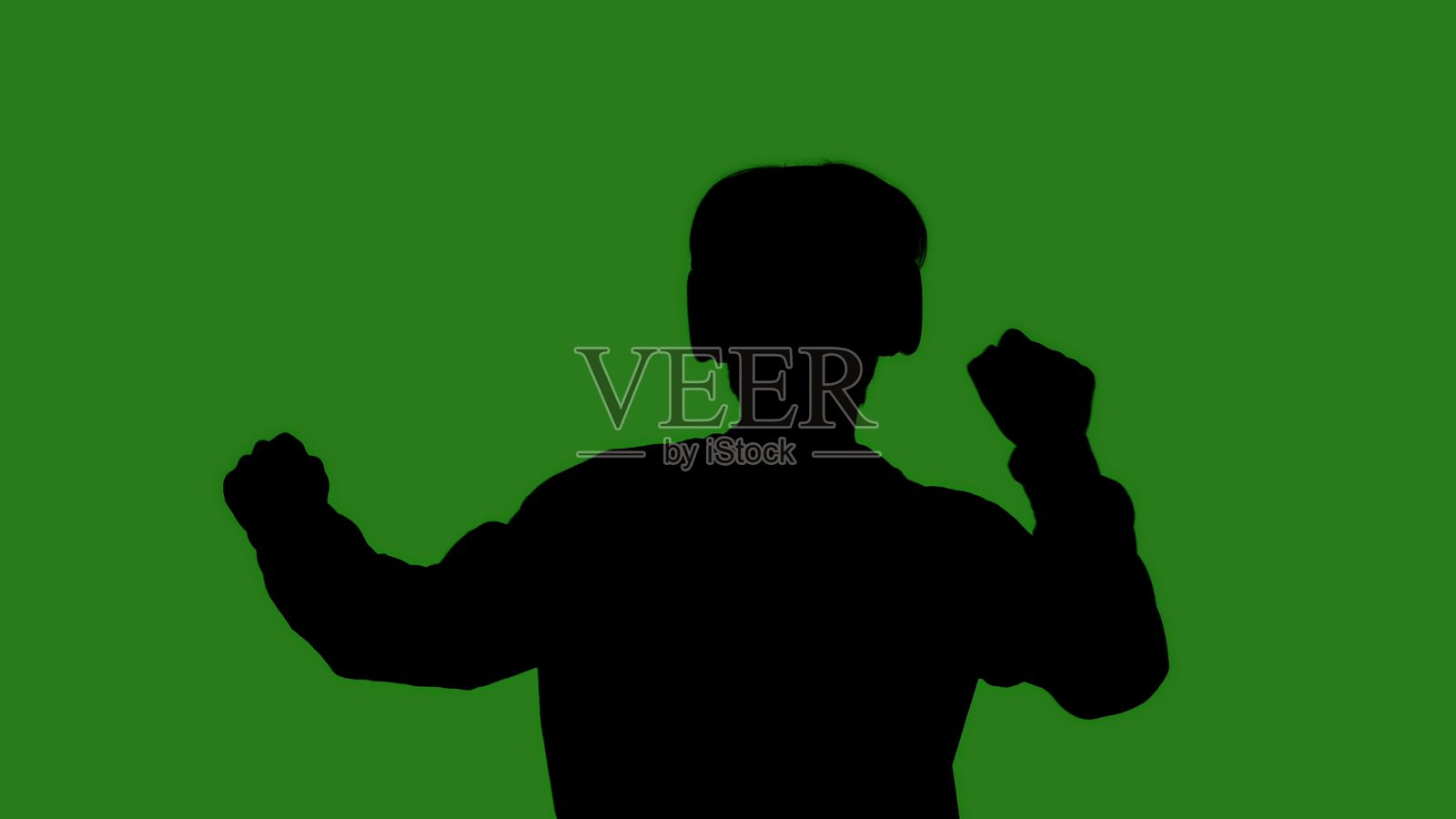 一个男人快乐地跳舞的黑色剪影,背景是绿色的色度键照片摄影图片