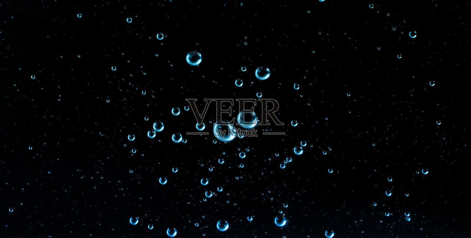 深色背景上漂浮着蓝色的水泡,非常适合用于护肤补水、化妆品精华概念、保湿广告、清洁美容主题以及科学产品设计。照片摄影图片