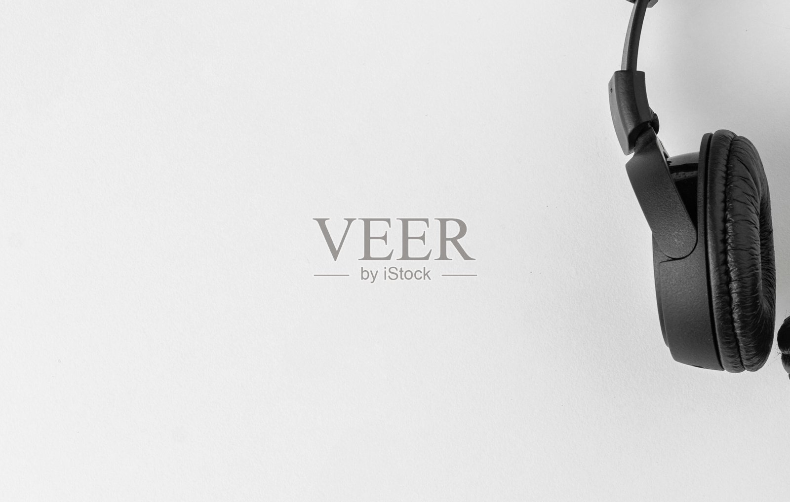 白色背景上悬挂的黑色耳机特写照片摄影图片