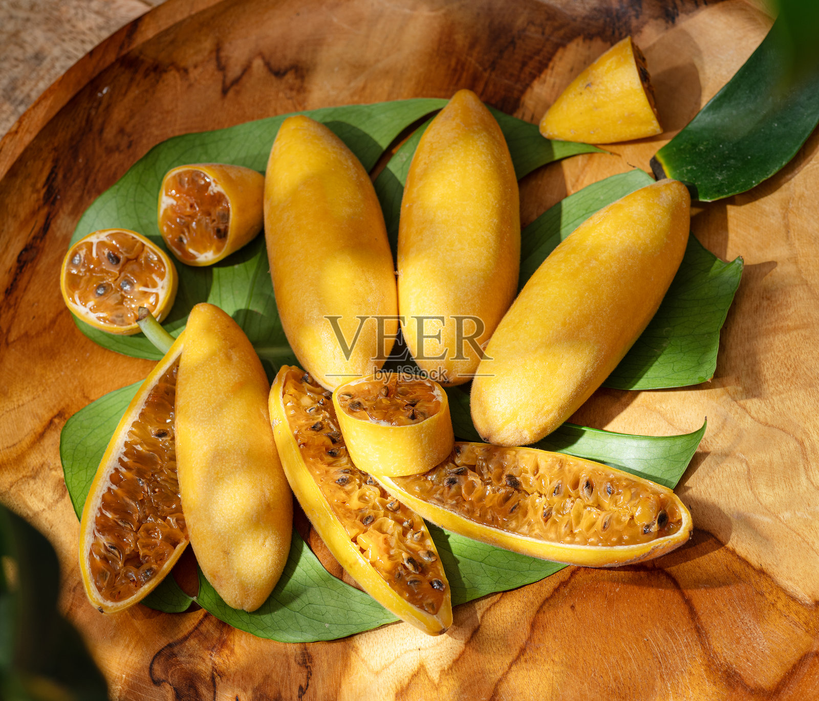 木盘上的香蕉西番莲果(也称curubas)及其切片,俯视视角。照片摄影图片