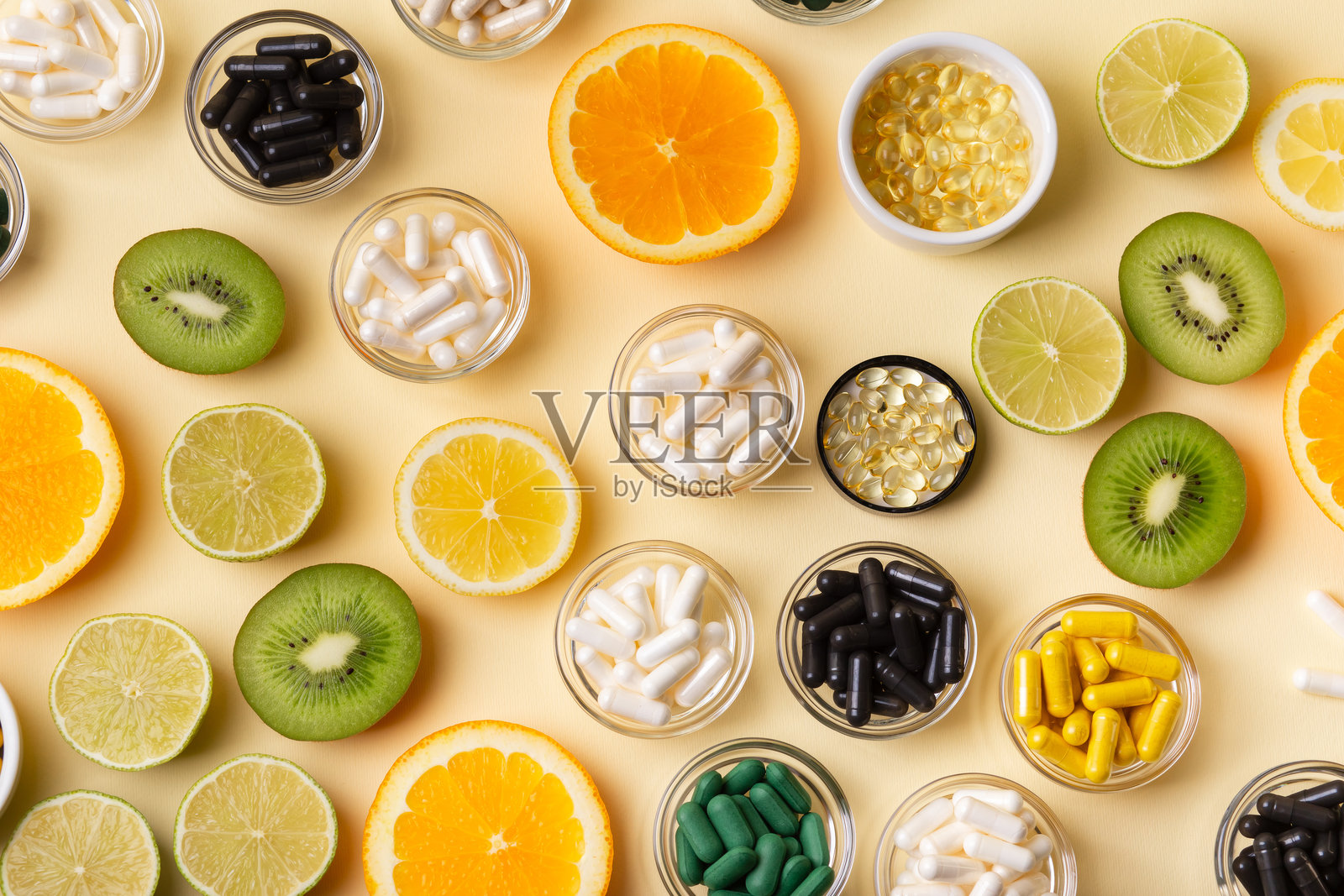 米色背景上的柑橘类水果、膳食补充剂、维生素和矿物质。照片摄影图片
