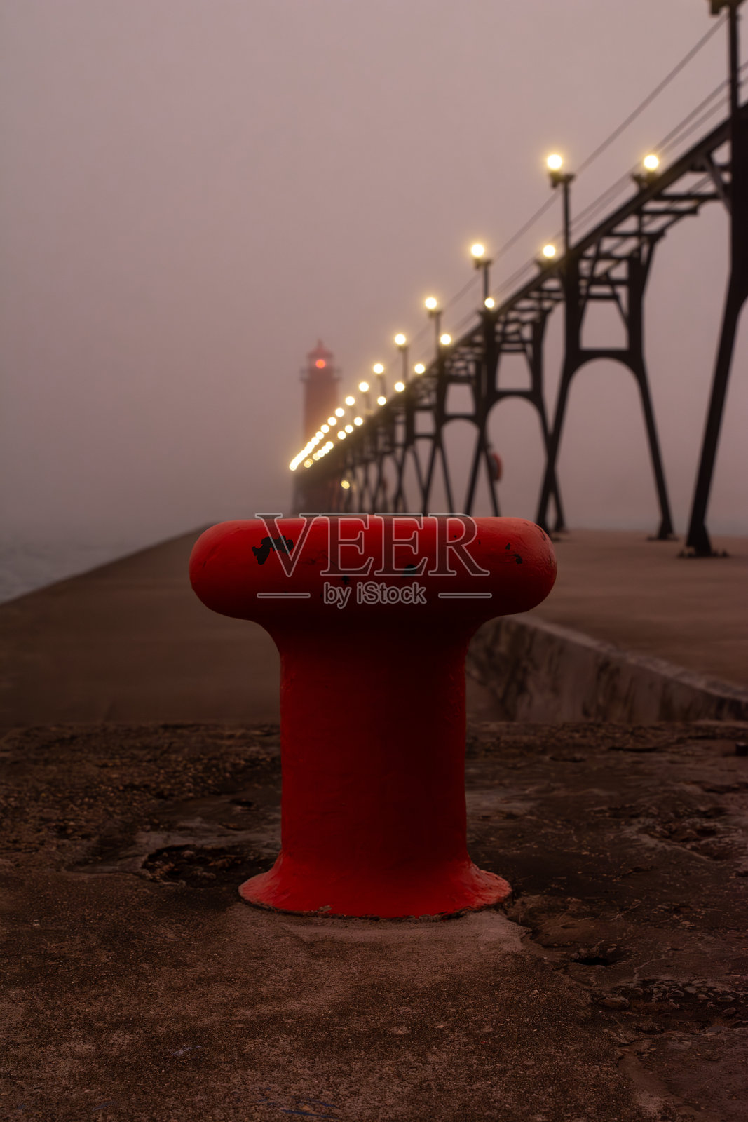 雾气蒙蒙的早晨,日出映照着格兰德黑文南码头灯塔,包括内灯标和外侧灯塔。照片摄影图片