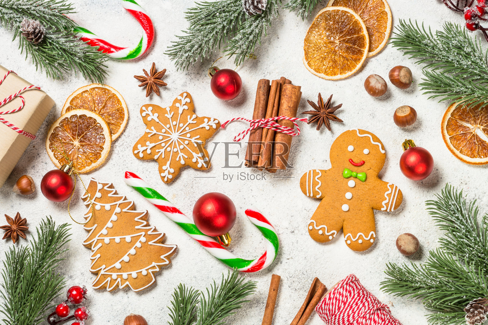 圣诞姜饼配香料和节日装饰,摆放在白桌上。照片摄影图片