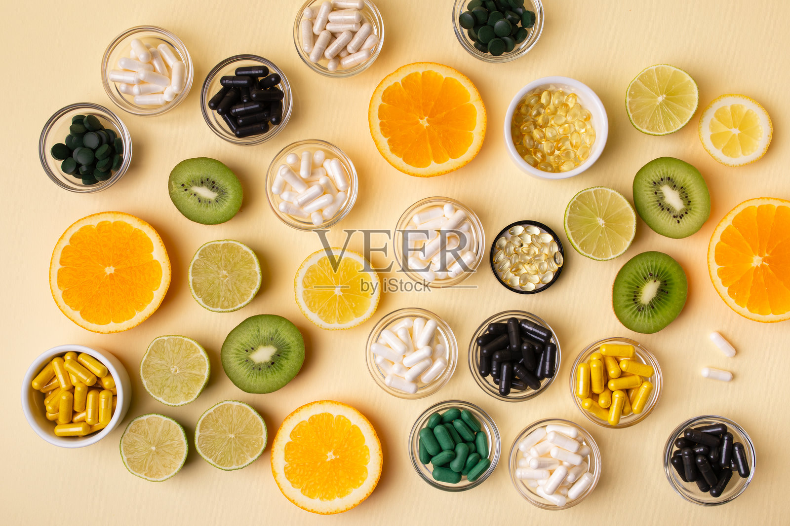 米色背景上的柑橘类水果、膳食补充剂、维生素和矿物质。照片摄影图片