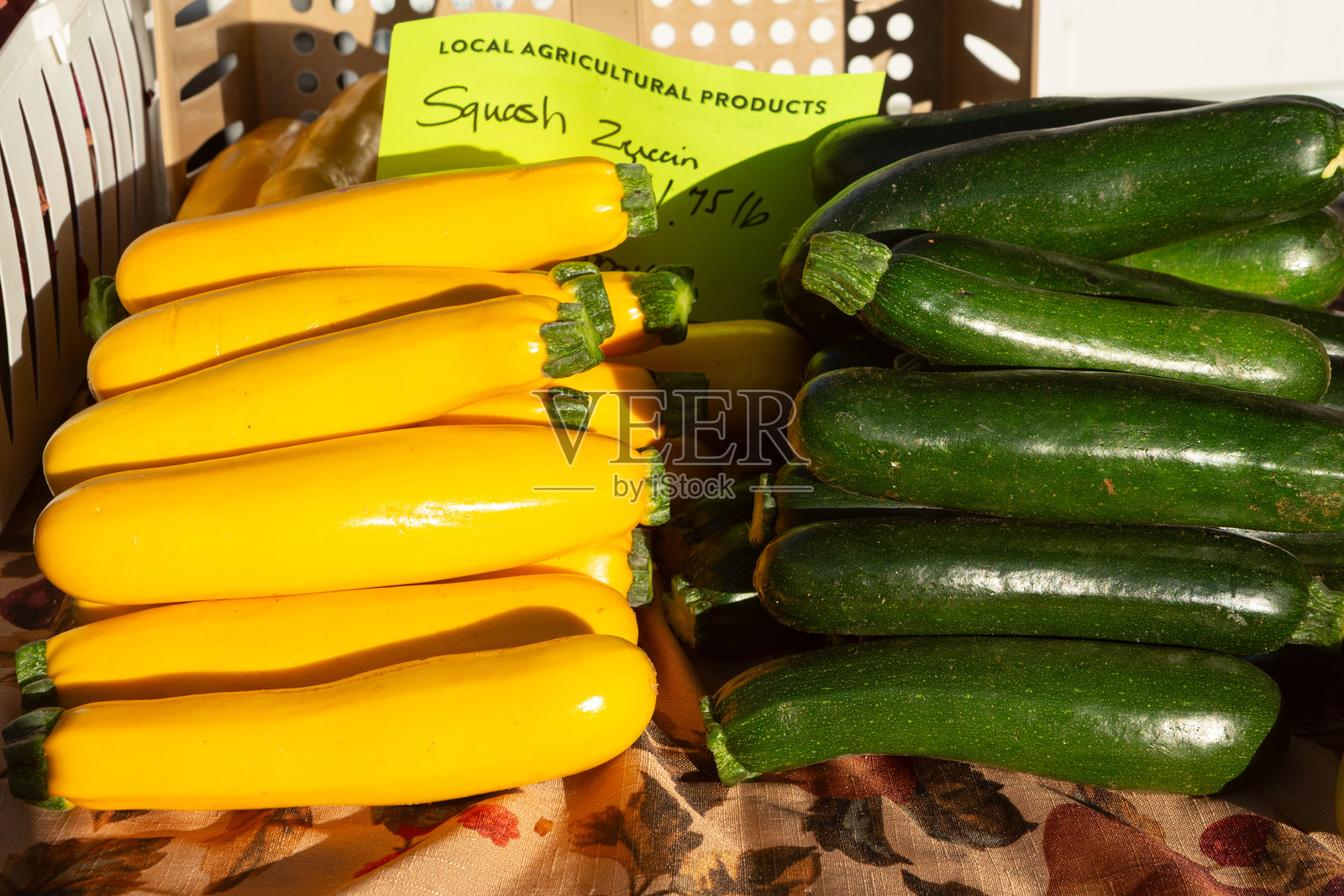 清晨的阳光照亮了当地农贸市场里黄绿相间的夏南瓜照片摄影图片
