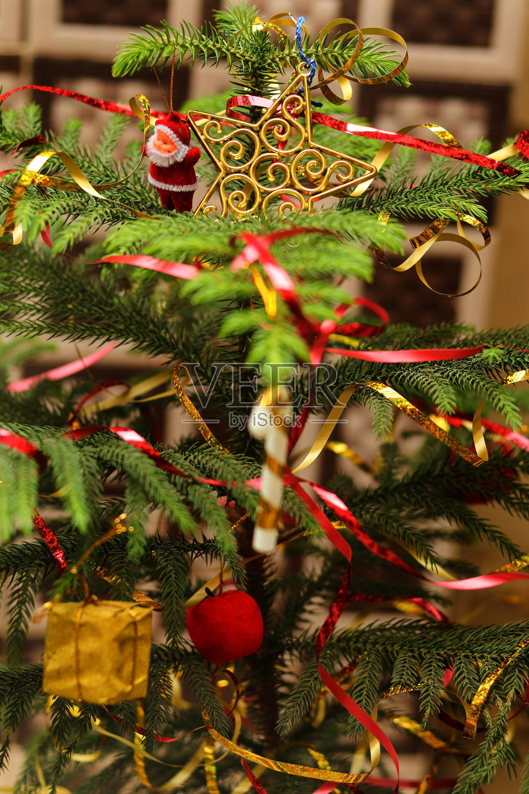 圣诞老人小玩具近景,挂在圣诞树上,树上还有彩球。圣诞派对或奇迹与圣诞老人。装饰圣诞树,背景是挂满彩球的圣诞树。照片摄影图片