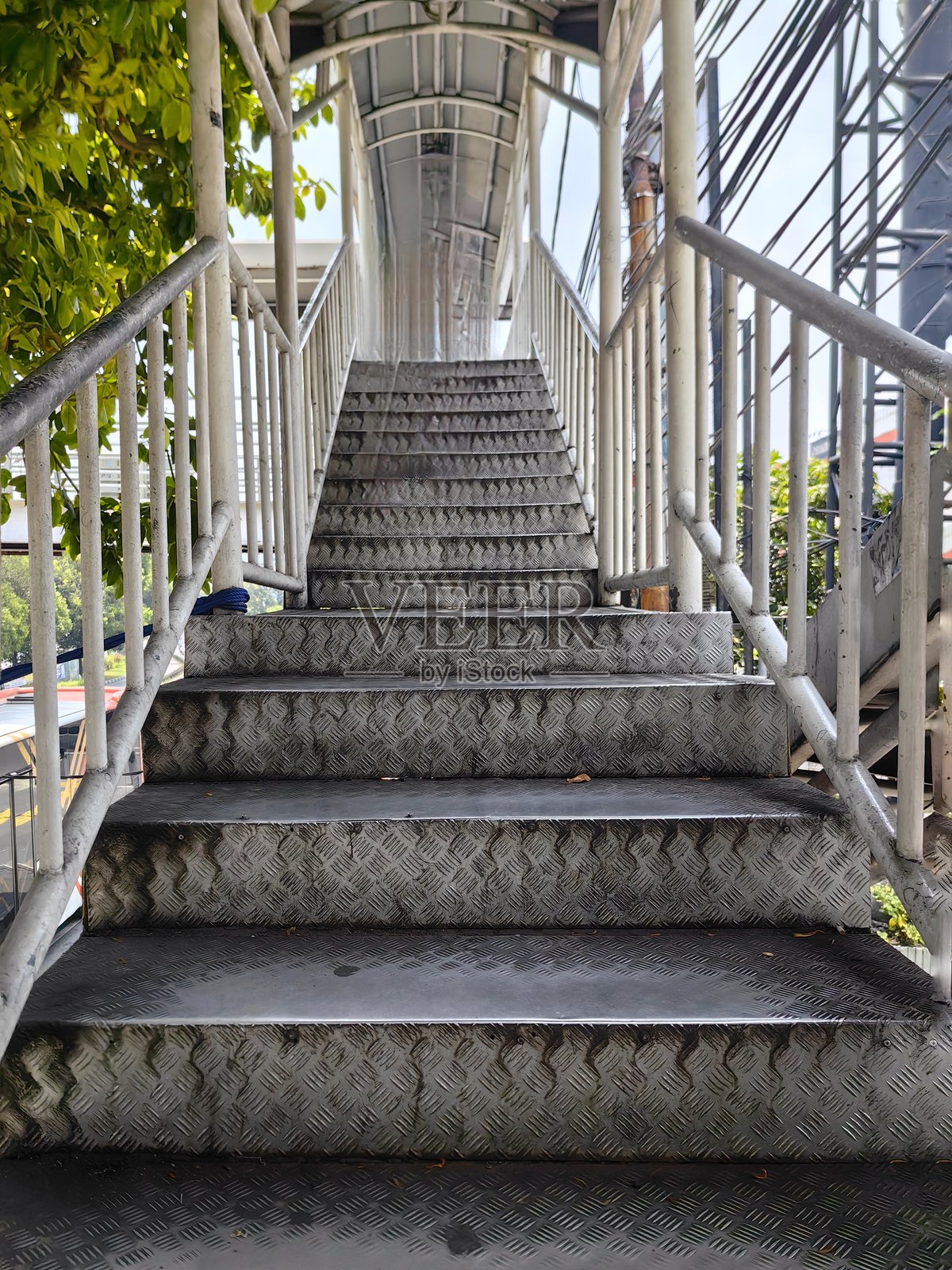 通往人行天桥的楼梯由金属制成,楼梯两侧都有扶手。照片摄影图片