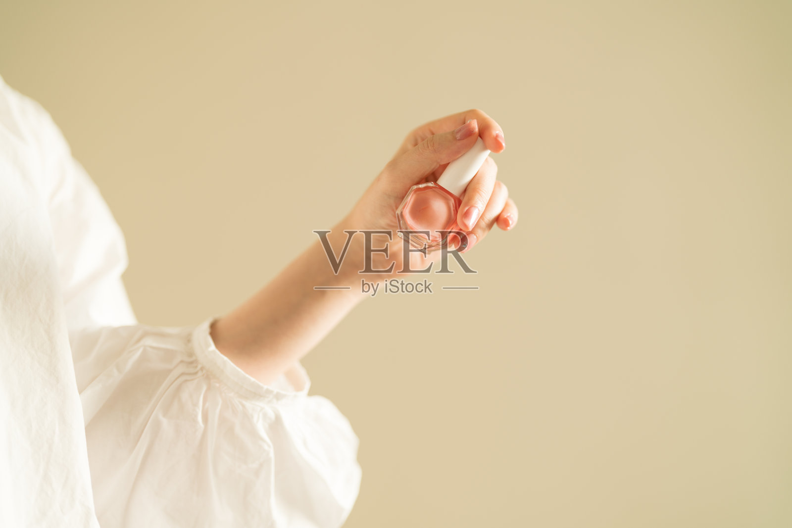 女士的手拿着粉色指甲油照片摄影图片