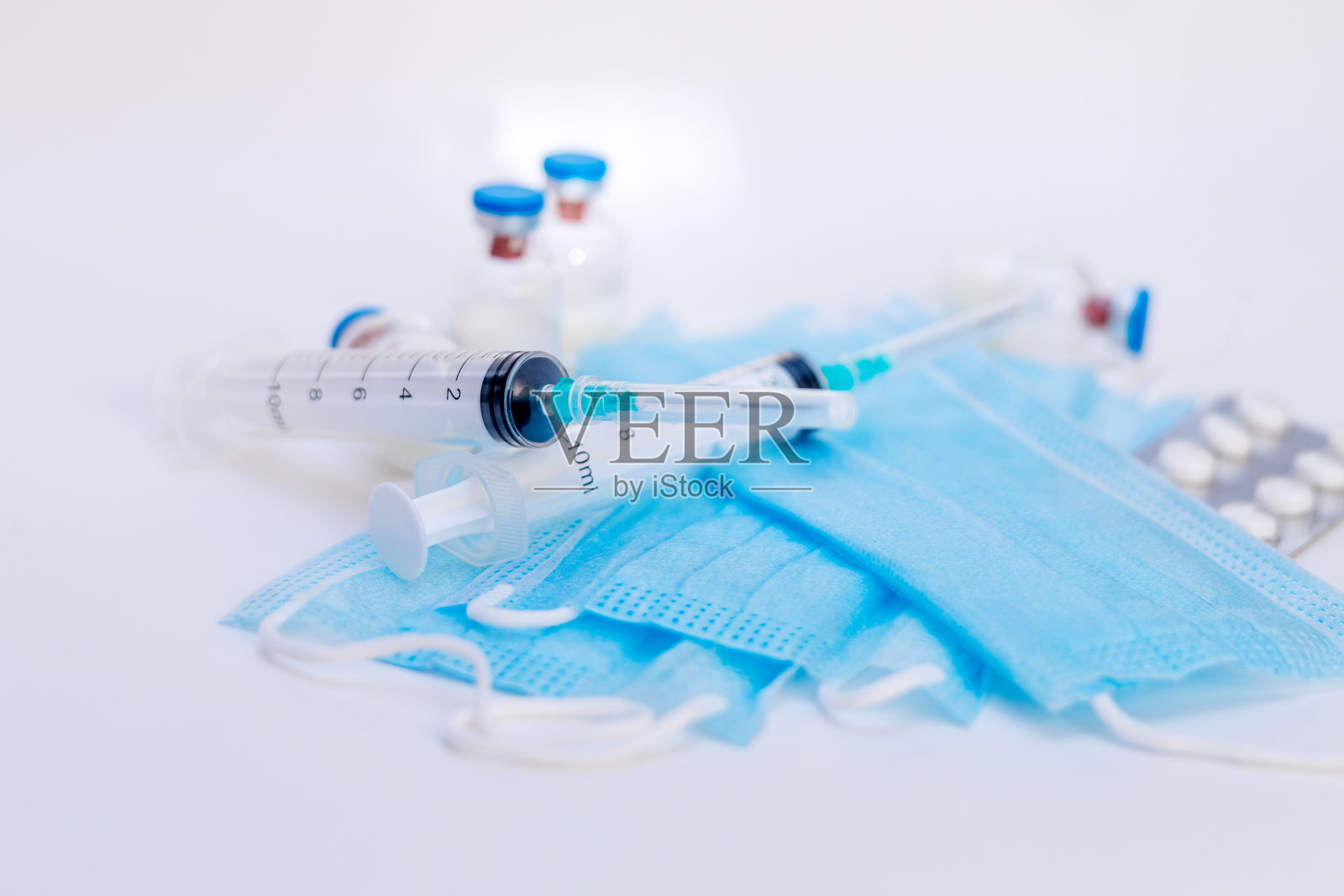 一次性注射器、医用口罩和退烧药。注射和病毒防护用品。照片摄影图片