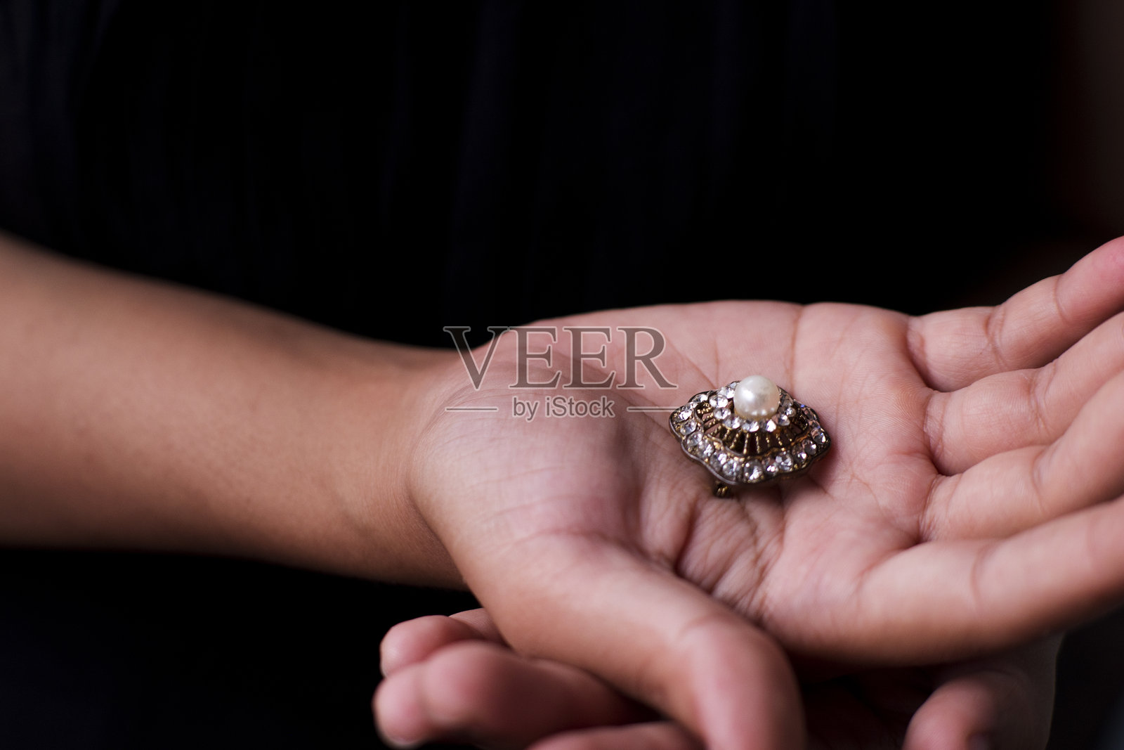 特写:手持一枚金戒指照片摄影图片